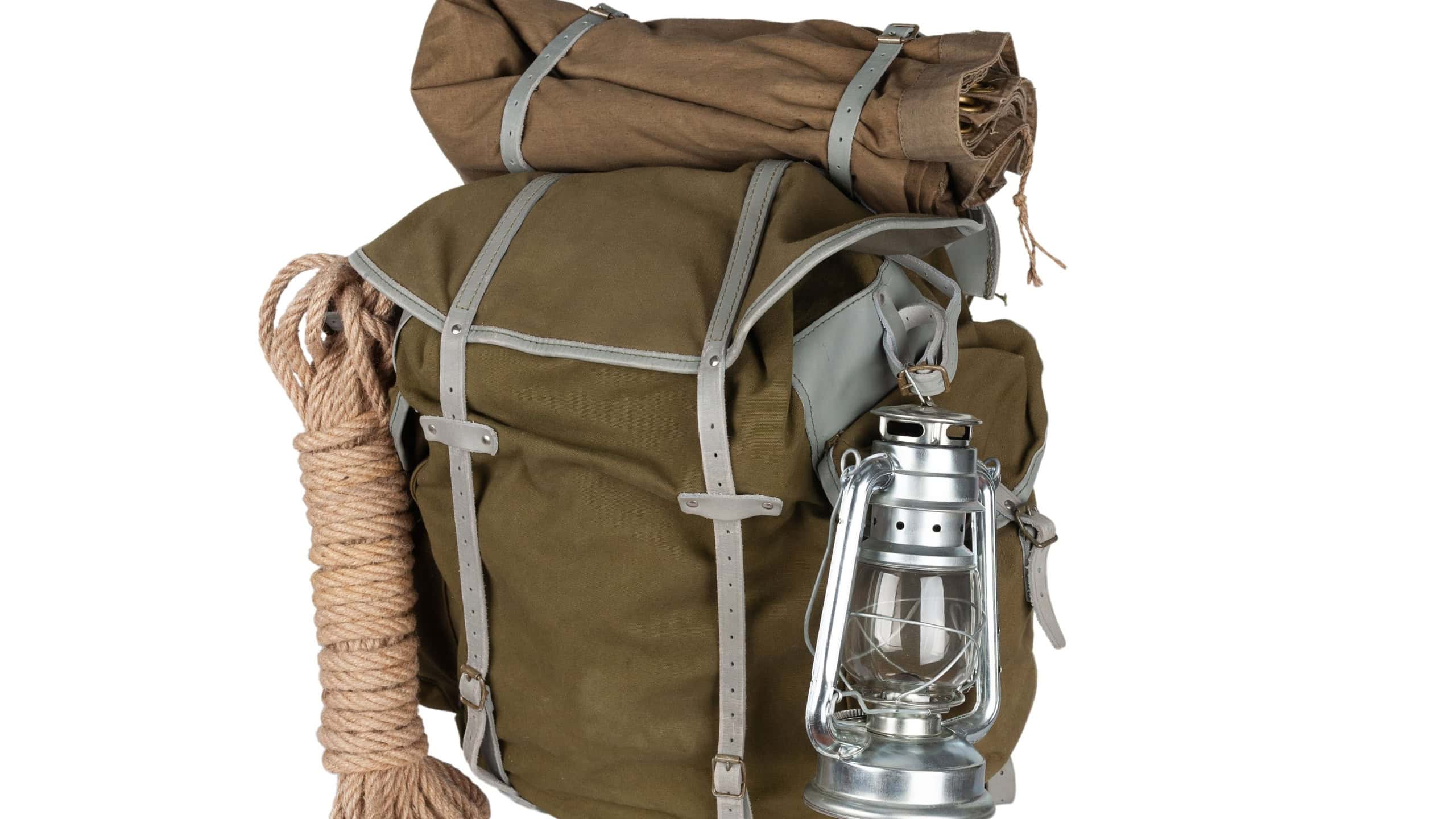 Antique vintage backpack with rope and gas lantern isolated on white background