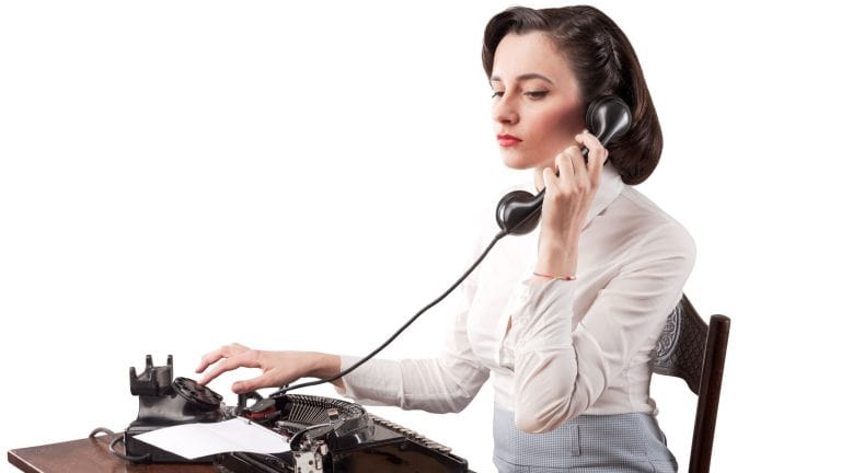Beautiful efficient secretary sitting at desk in the office and working, she is having a phone call, vintage style