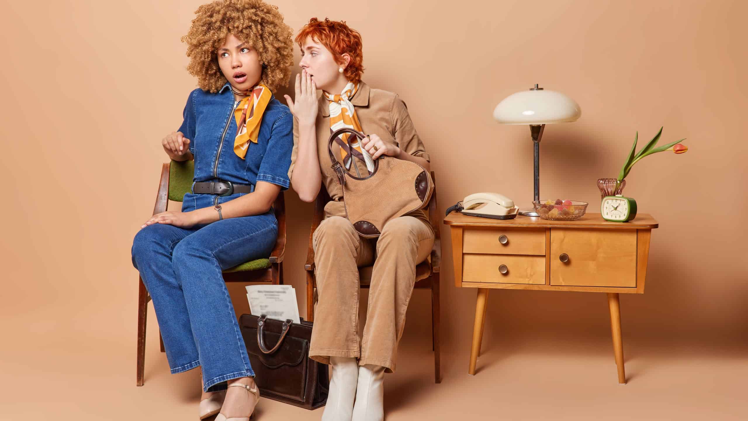 Women friends or colleagues wearing vintage outfits whisper secret and gossip between each other surrounded by classic retro furniture leaving viewers captivated by allure of nostalgia sit on chairs
