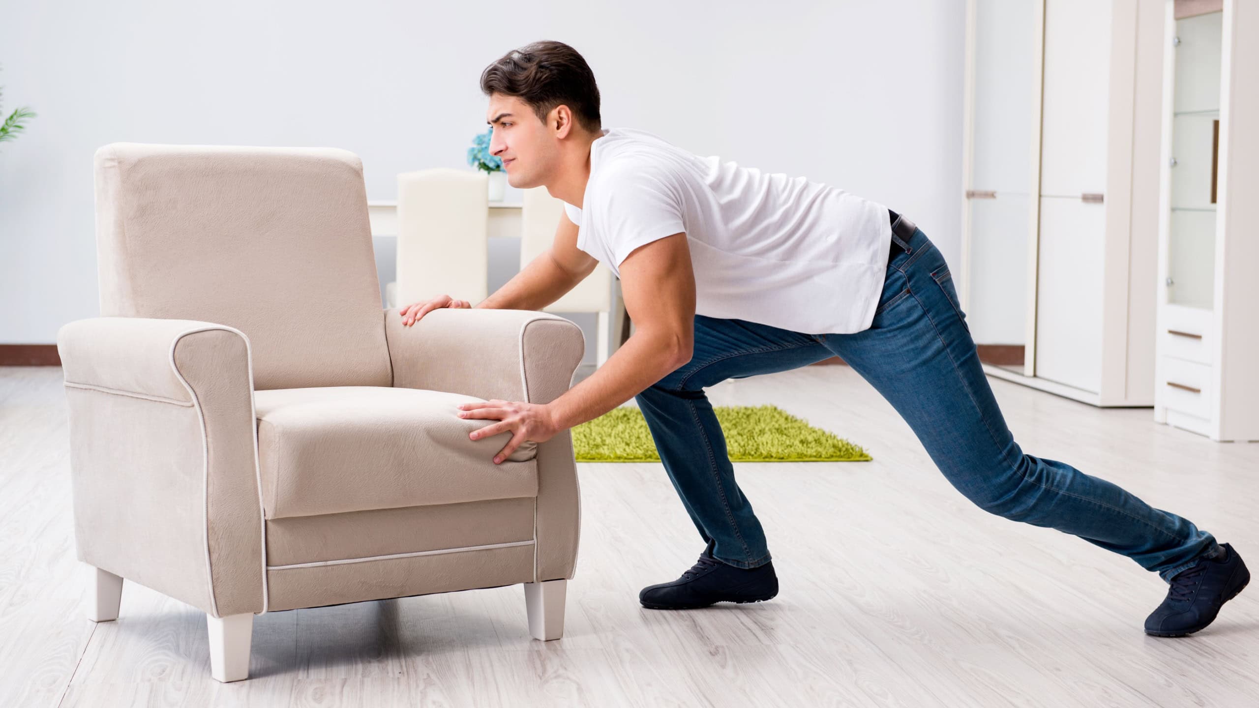 Young man moving furniture at home
