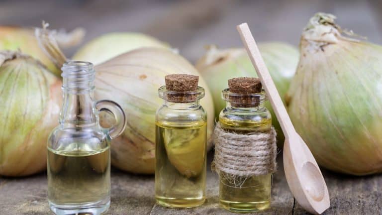 Onion juice and vegetables on a wooden table. Home-made syrup for the treatment of influenza. Dark background.