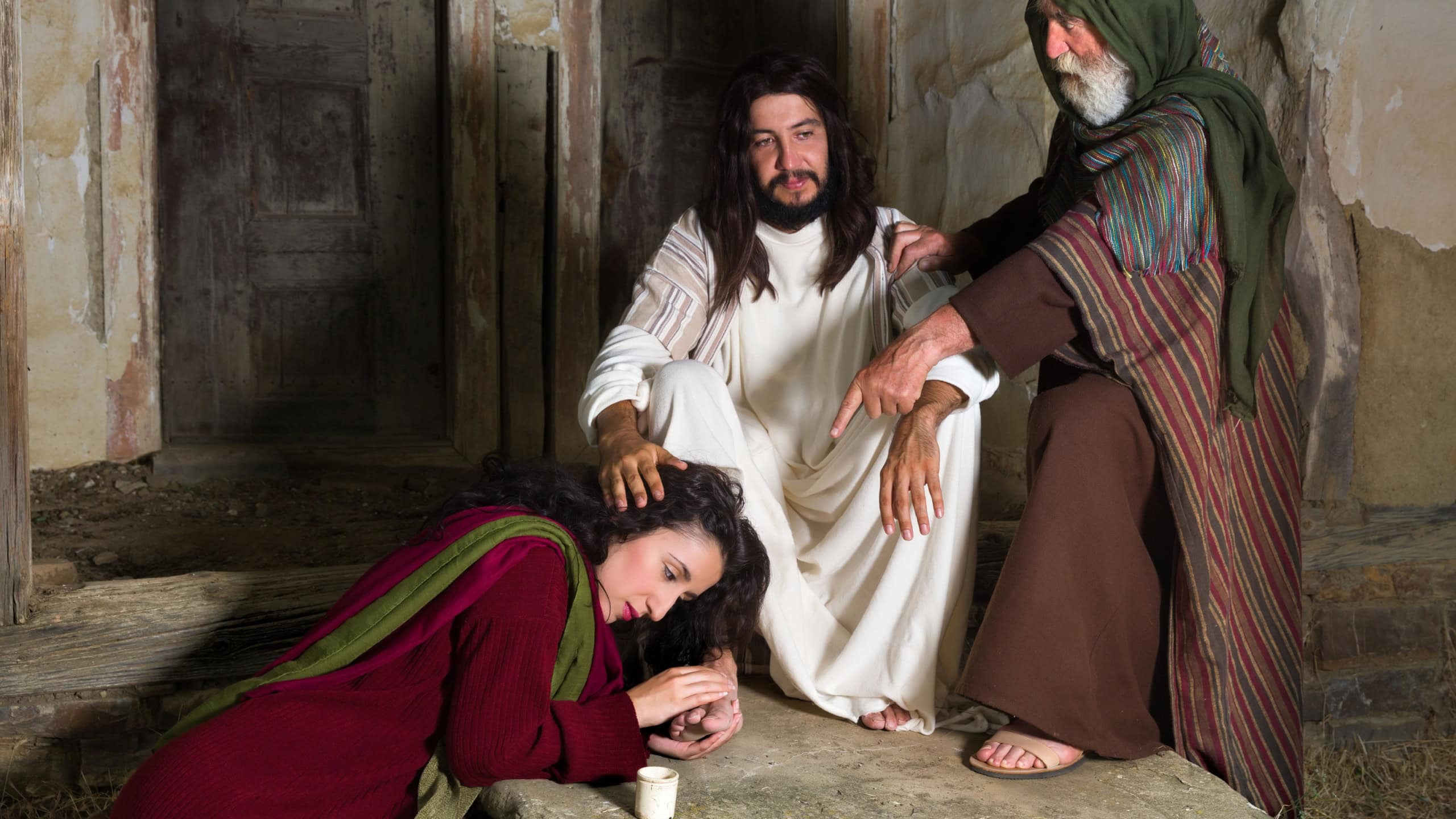 Mary of Bethany crying of shame and anointing Jesus' feet, while Judas is protesting against the waste