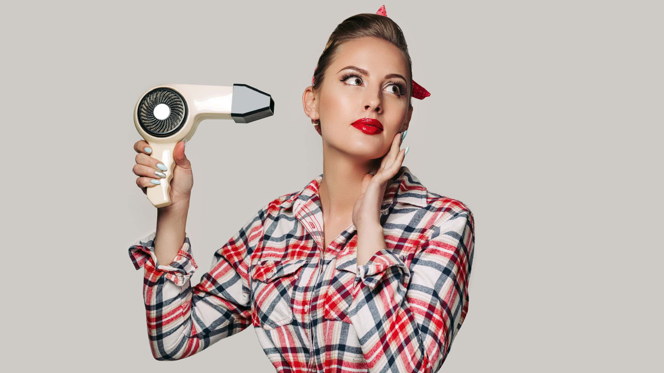 Happy young brunette woman with hair dryer. pin-up retro style