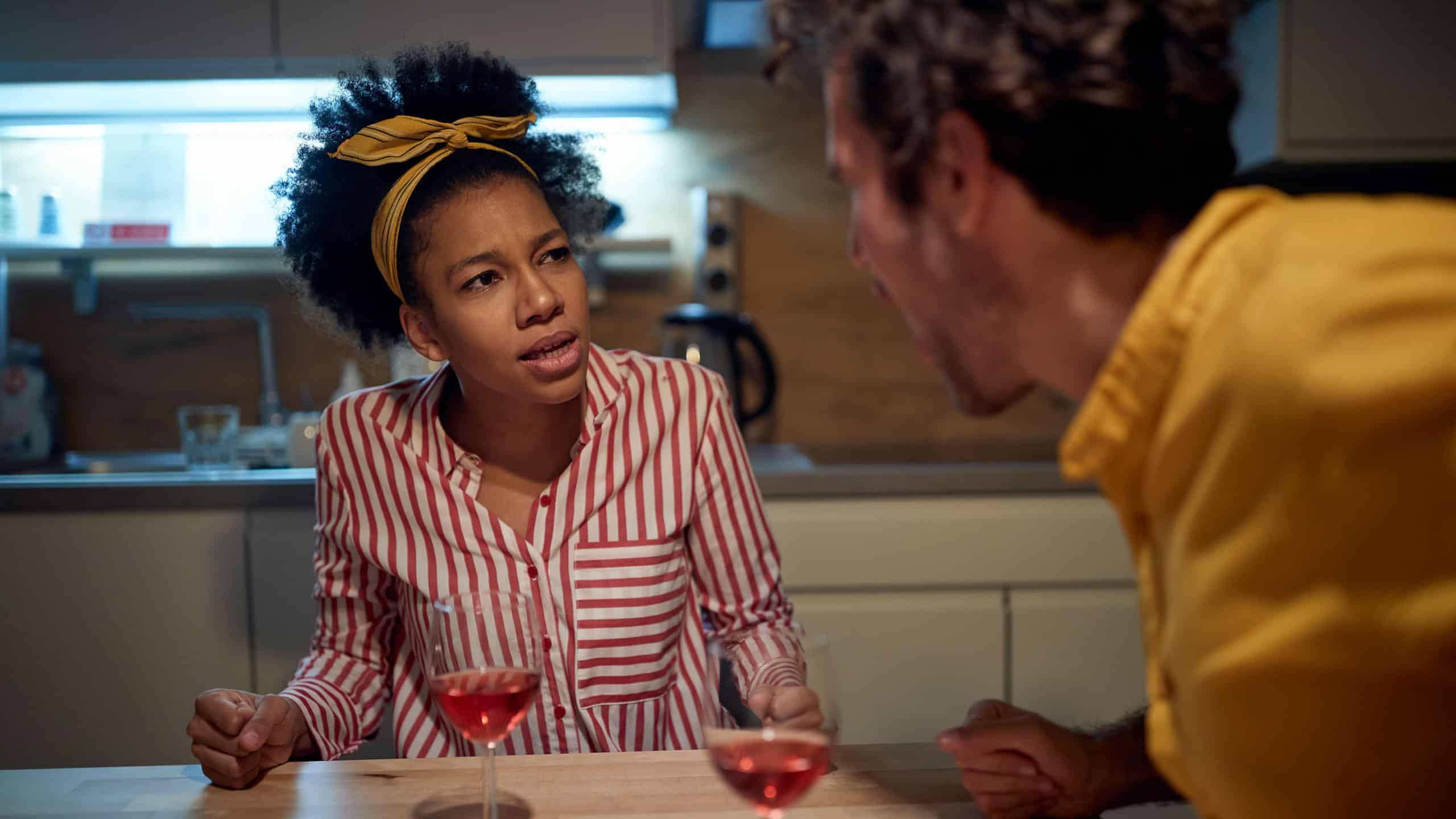 A young couple arguing while eating in a tense atmosphere at the kitchen. Dinner, relationship, together, home