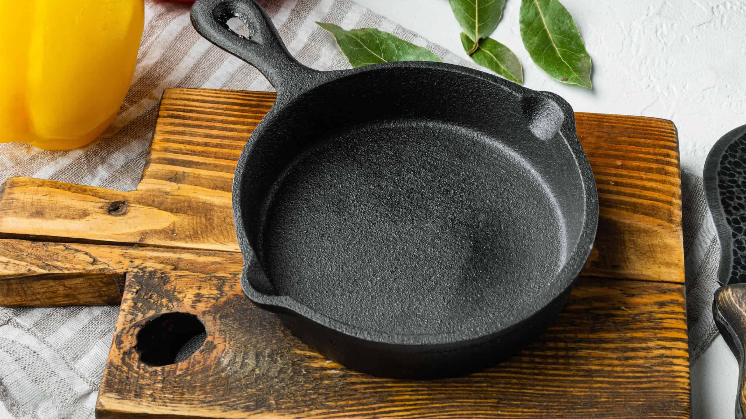 Empty frying cast iron pan background, kitchenware cooking concept set, on white stone surface, with copy space for text