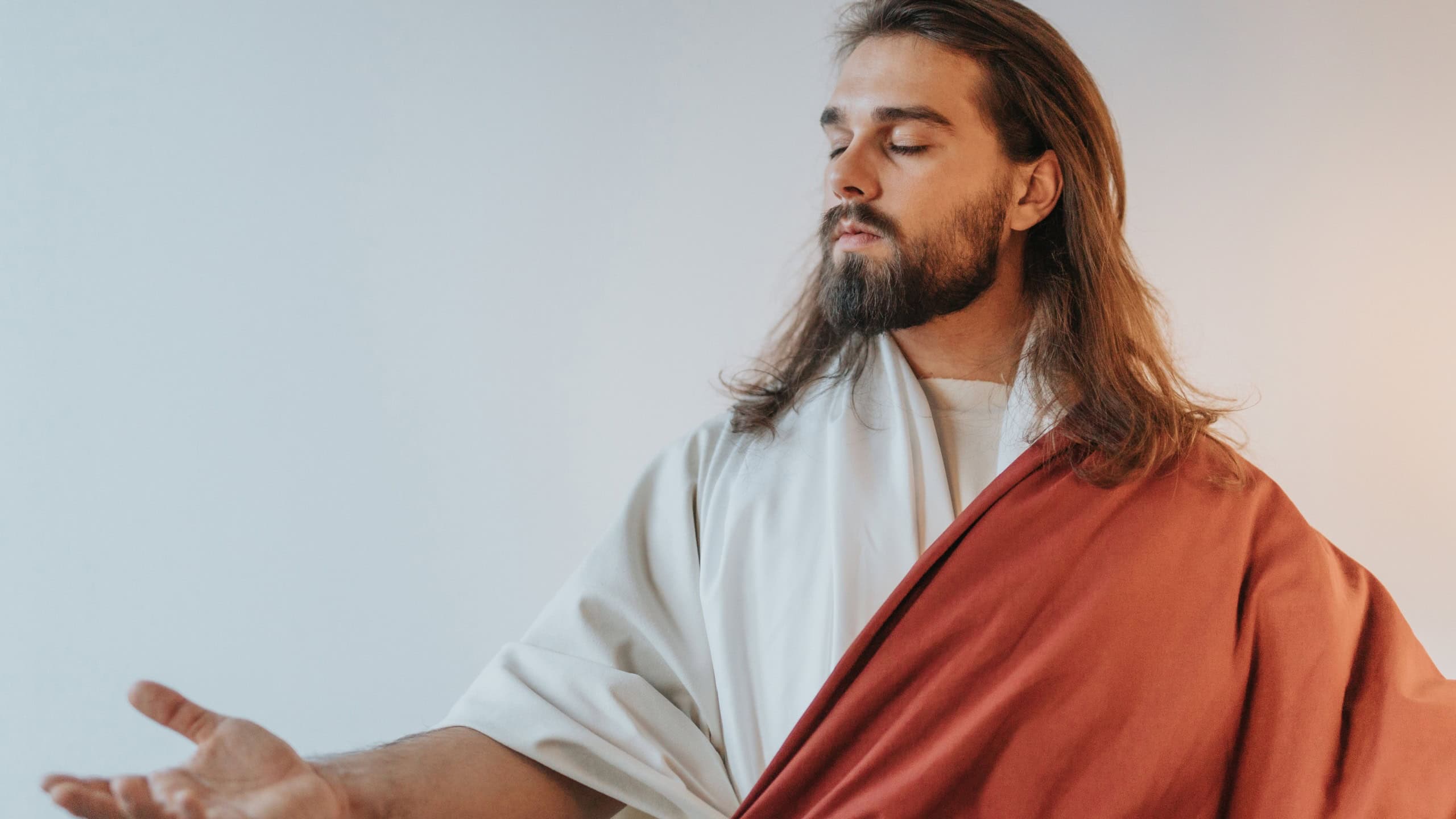 Jesus Christ with his eyes closed reaching out the hand