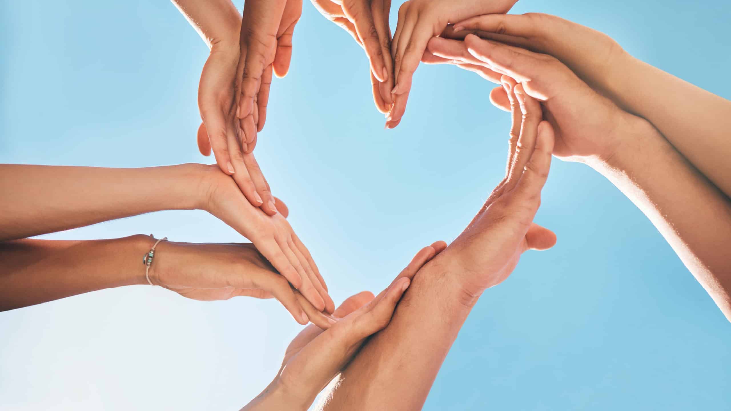 Heart, love and group hands for support, care and community with outdoor summer sunshine, blue sky and mock up. Group of people with care sign for solidarity, health and wellness background mockup