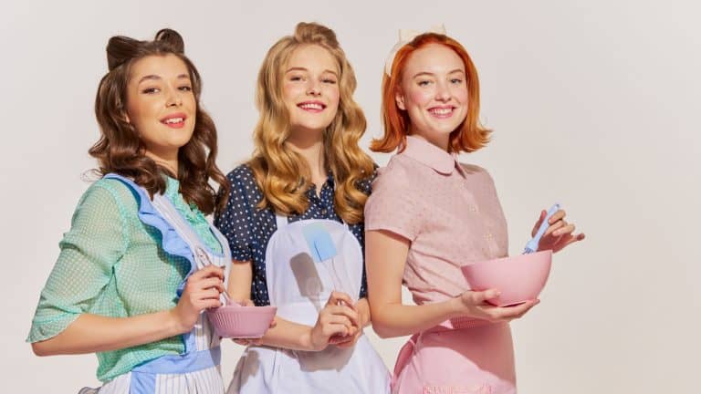 Portrait of beautiful young women, housewives with cooking tools isolated over grey background. Pop art. Concept of beauty, retro style, fashion, elegance, 60s, 70s, family. Copy space for ad