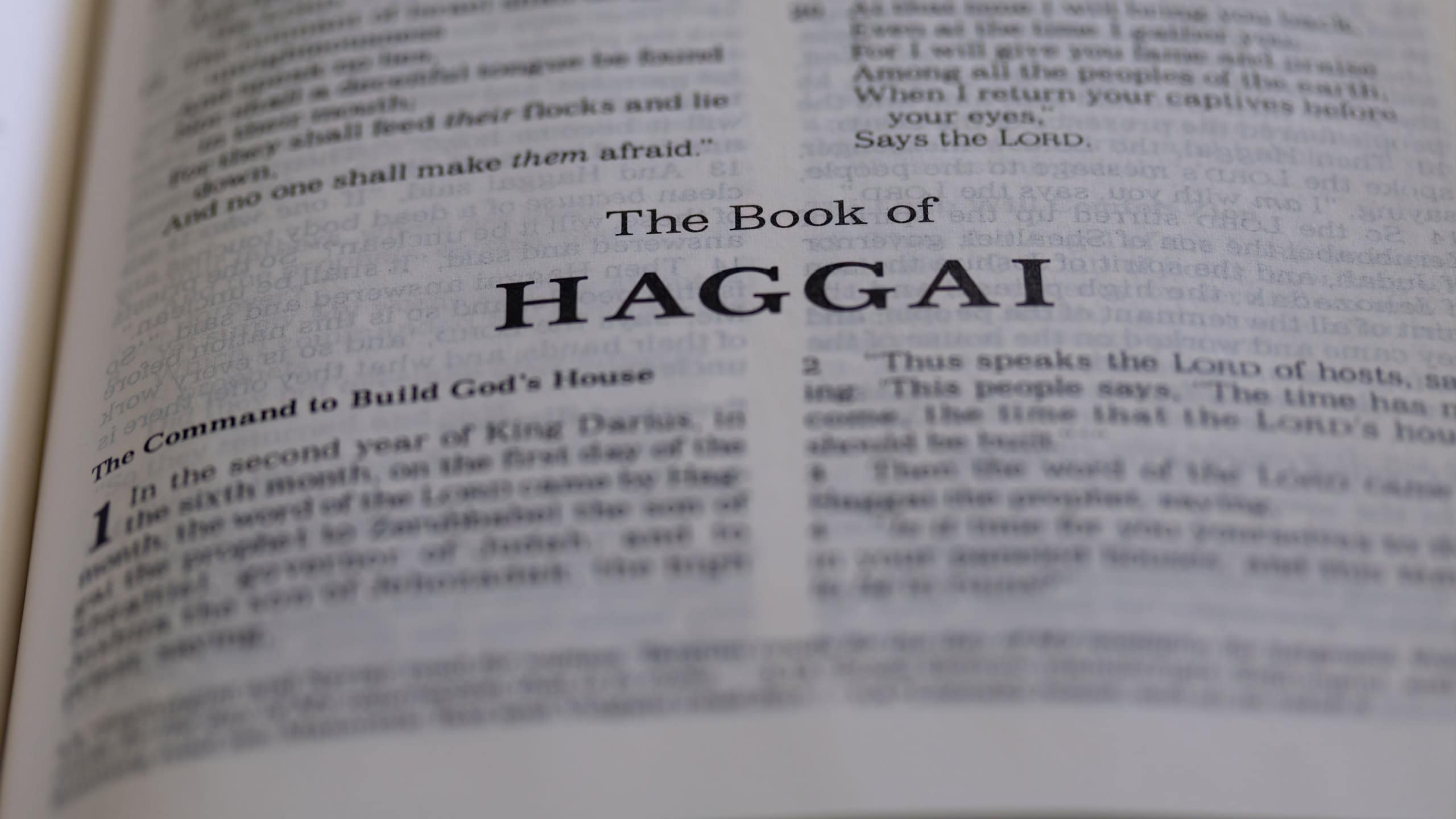 This image is of an open book on a table with text that reads the book of Haggai