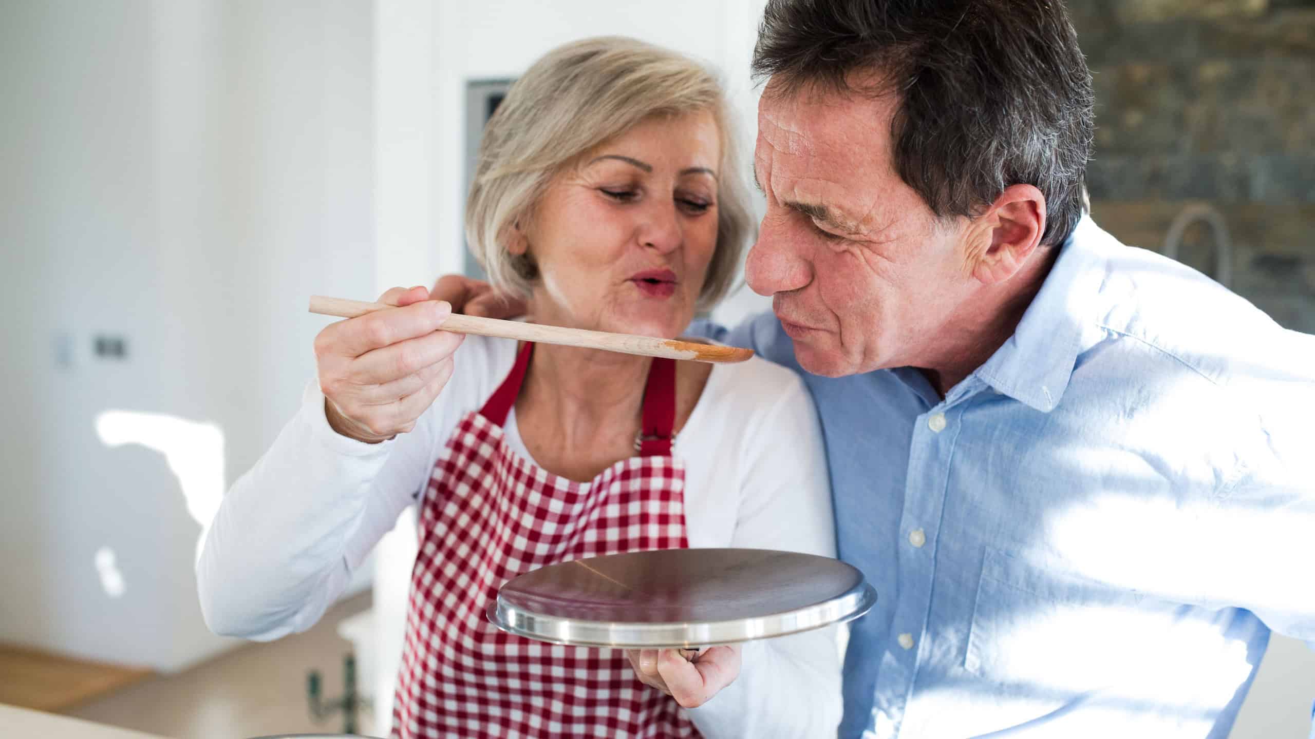 Senior couple in the kitchen cooking together.