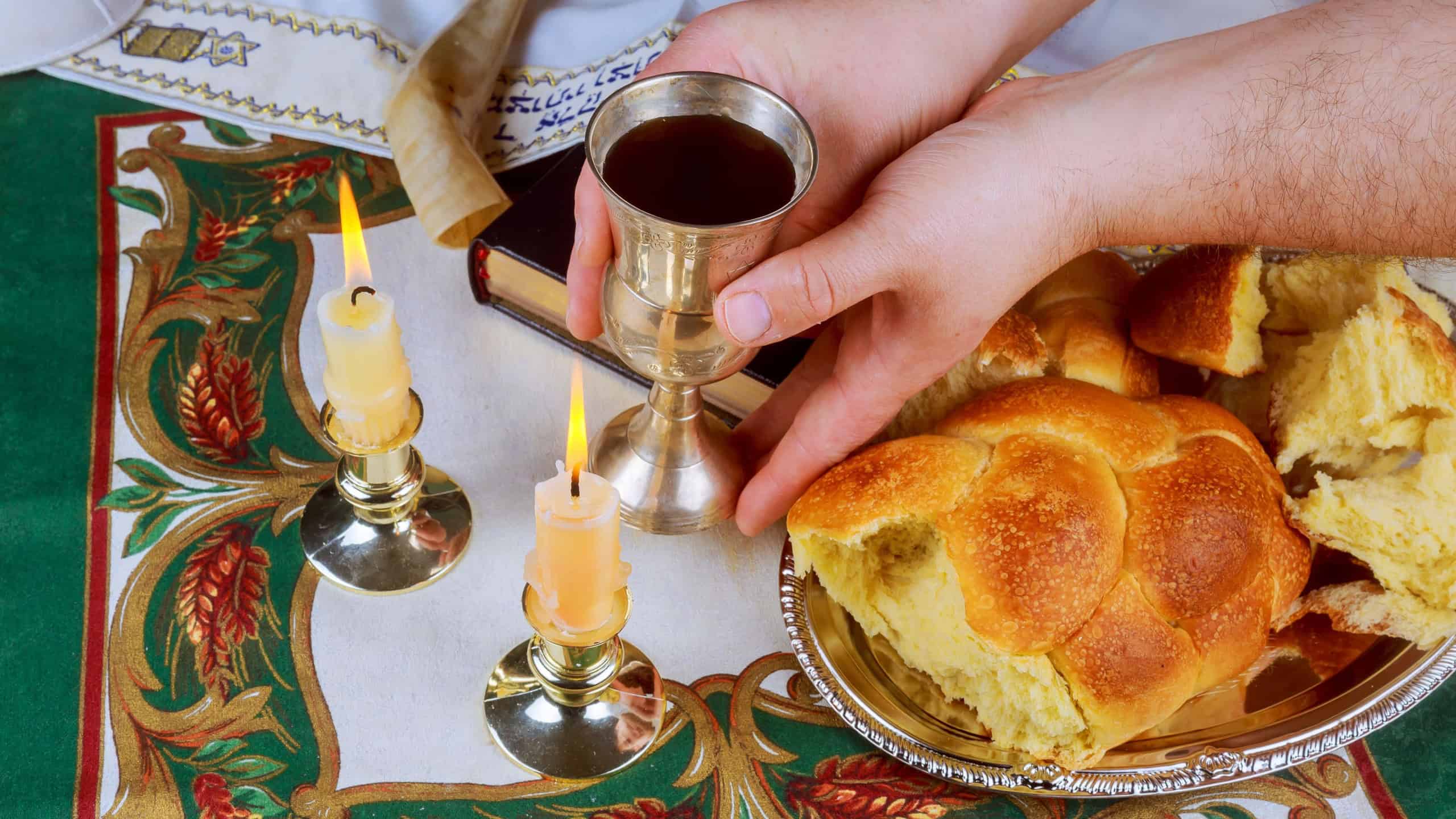 Sabbath image. challah bread, sabbath wine and candelas on wooden table. glitter overlay