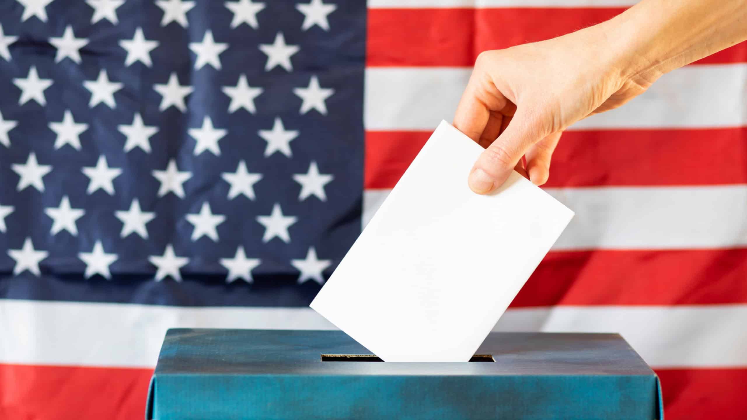 usa elections the hand of woman putting her vote in the ballot box