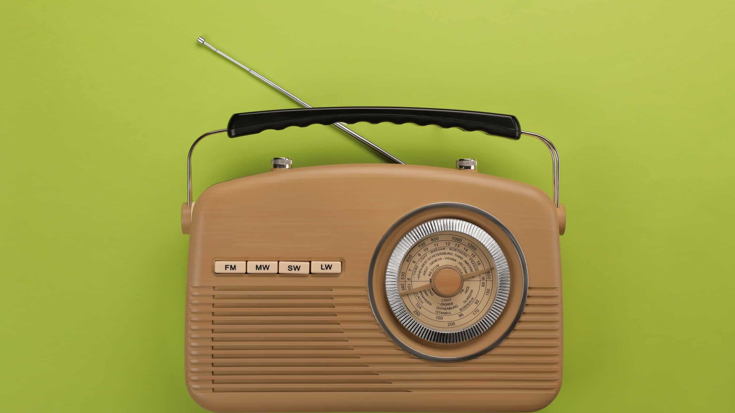 Retro radio receiver on light green background, top view
