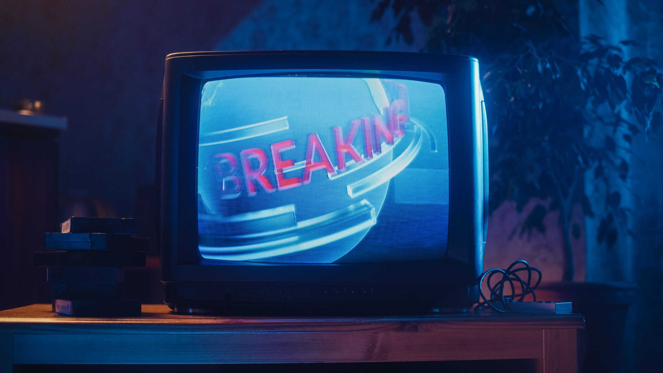 Close Up Footage of a Dated TV Screen. Breaking News Report Starting. Intro with Word Breaking Revolving Around Digital Earth on Vintage Display. Nostalgic Retro Nineties Technology Concept.