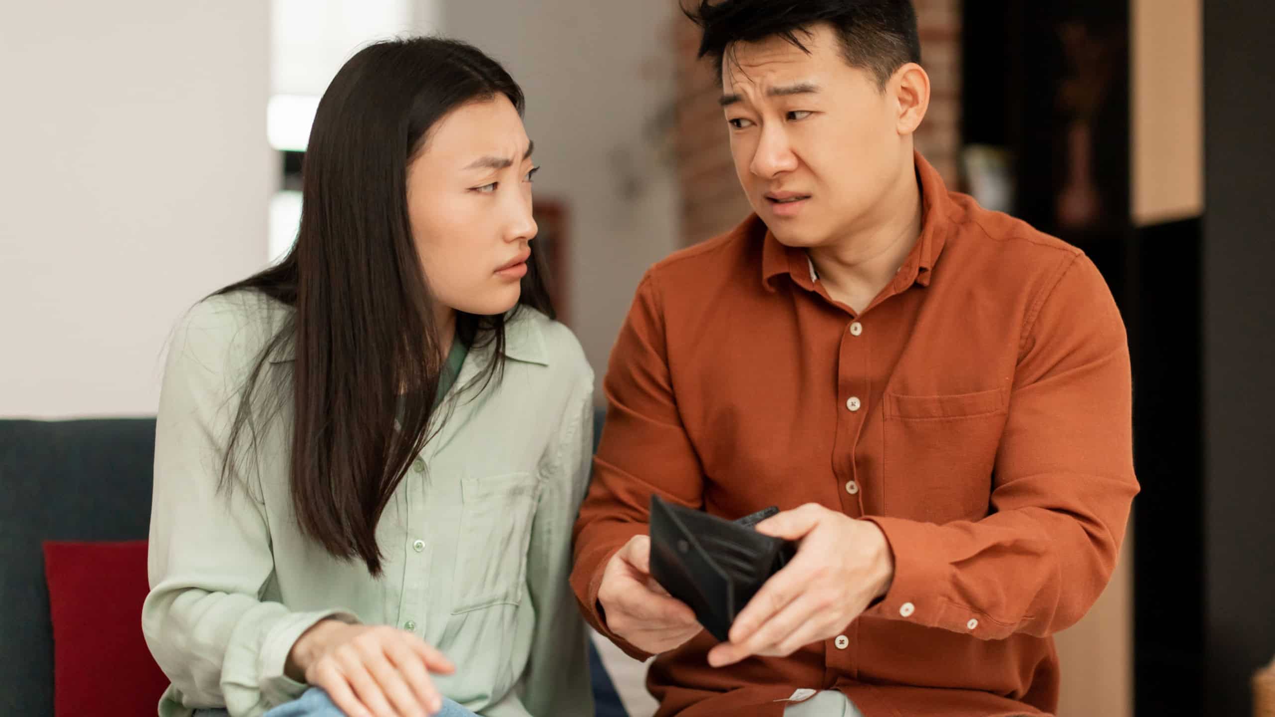 Asian married couple, wife and husband, confused by empty wallet, the calculation of expenses, do not have money. Mortgage, debt-causing loan, bankruptcy