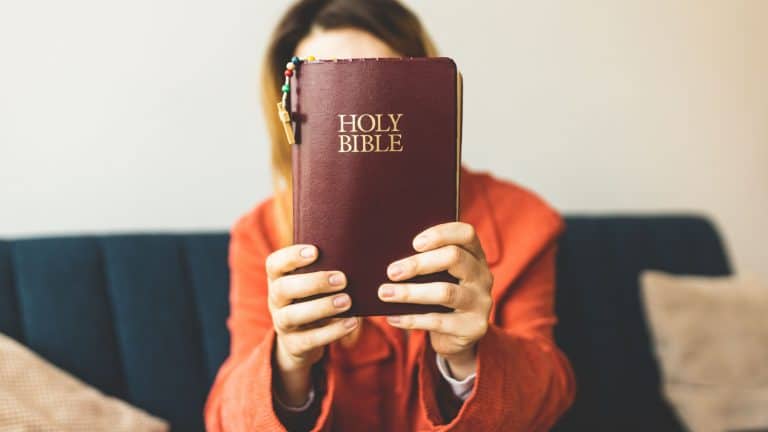 A woman is holding a Bible and praying. Studying the Holy Scriptures. Spiritual growth. Faith and spirituality. Bible study and prayer. Oration.
