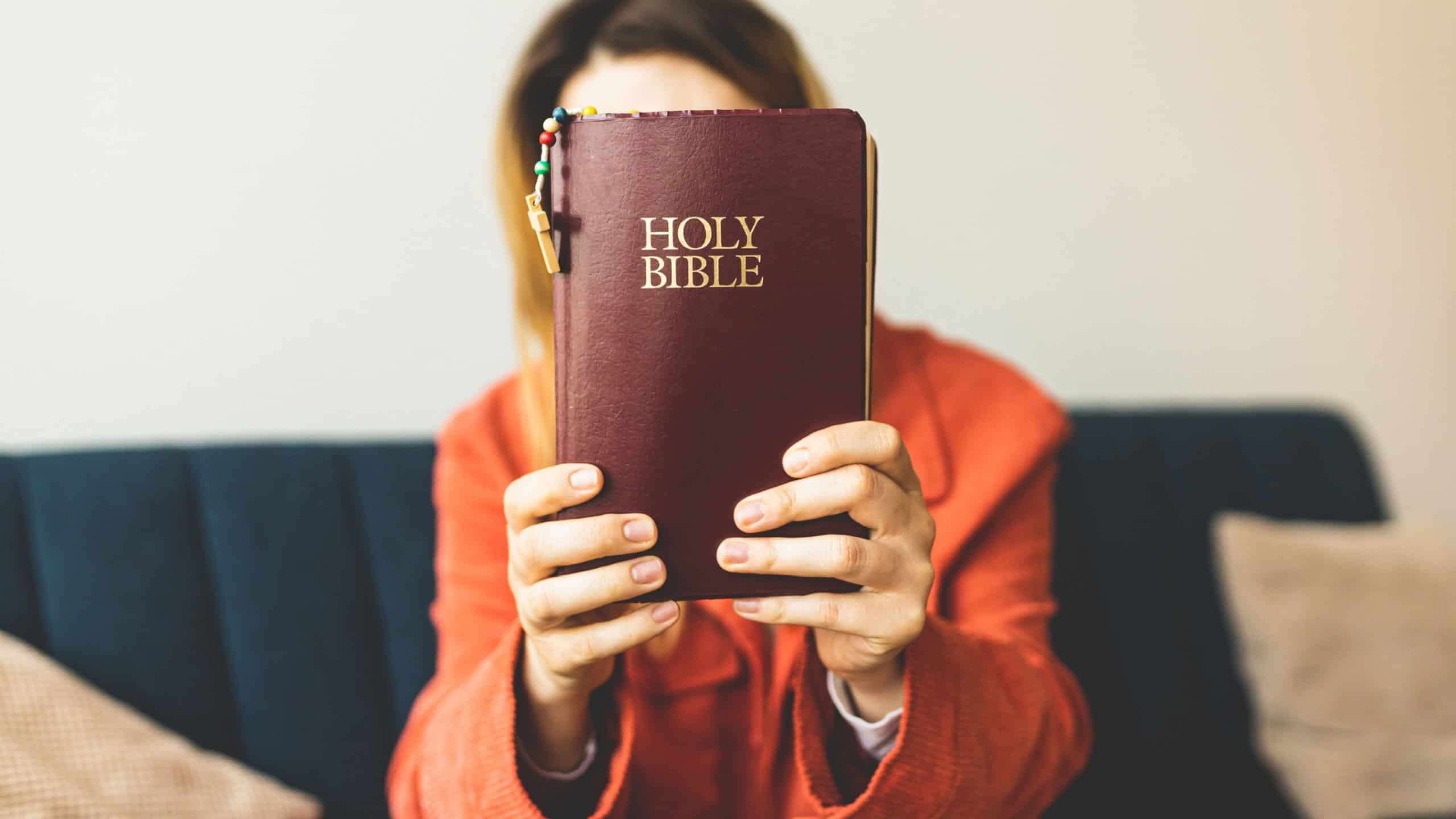 A woman is holding a Bible and praying. Studying the Holy Scriptures. Spiritual growth. Faith and spirituality. Bible study and prayer. Oration.