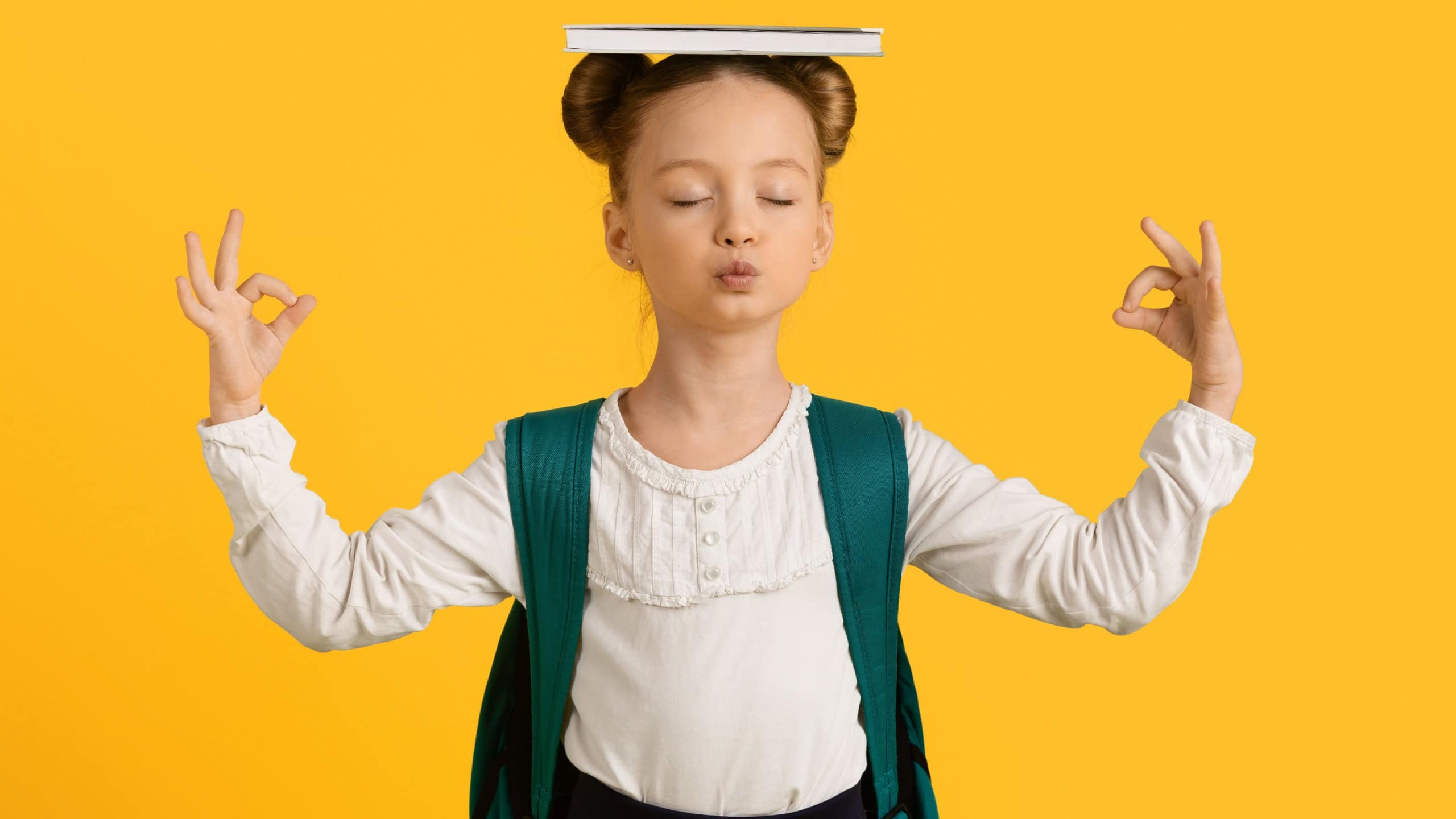 Keep Calm. Cute Little Schoolgirl Meditating With Book On Head And Closed Eyes, Adorable Female Child Coping With Learning Stress, Standing Isolated On Yellow Background, Copy Space