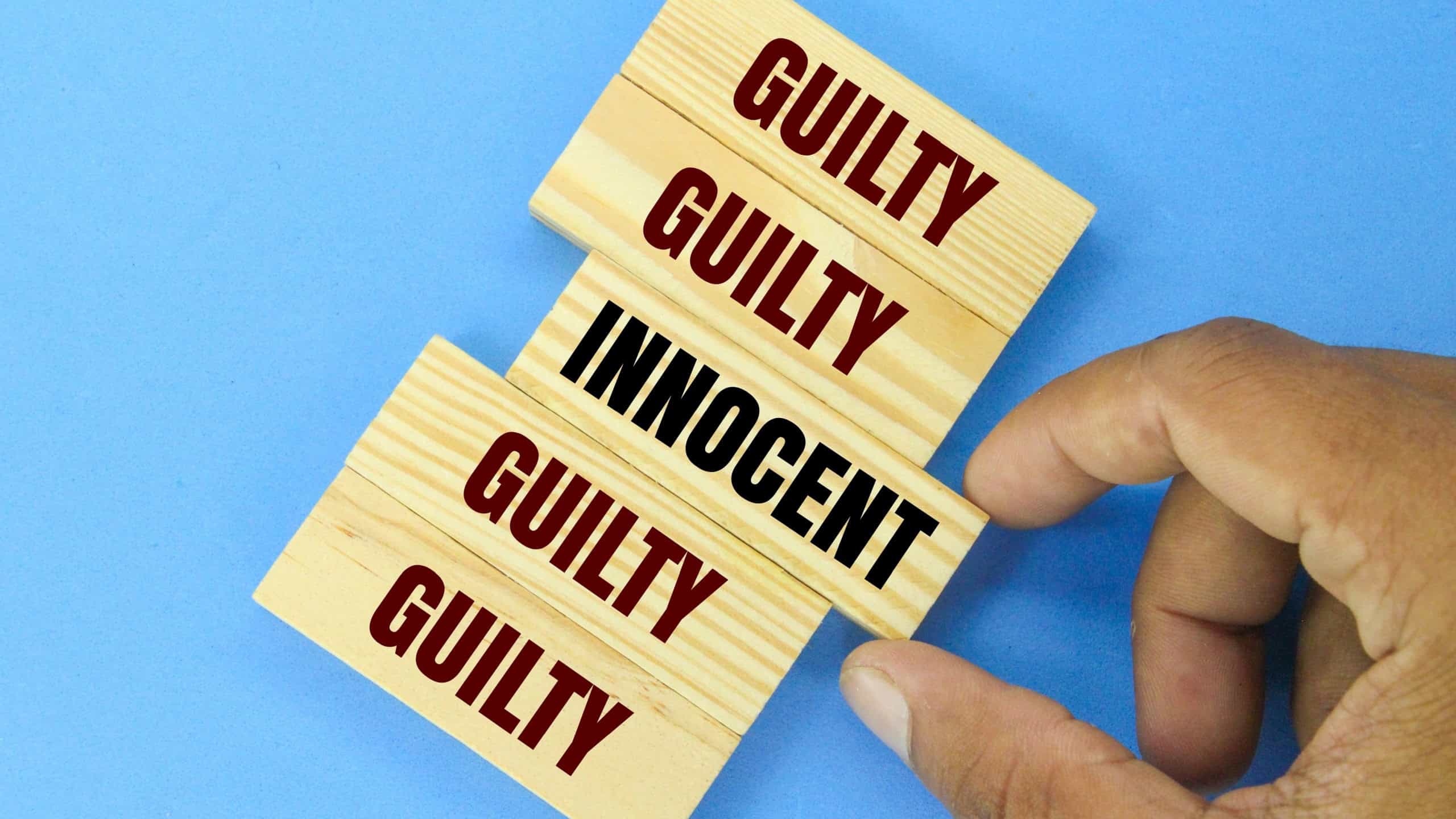 wooden arrangement with the words guilty and innocent. the concept of guilty or not guilty