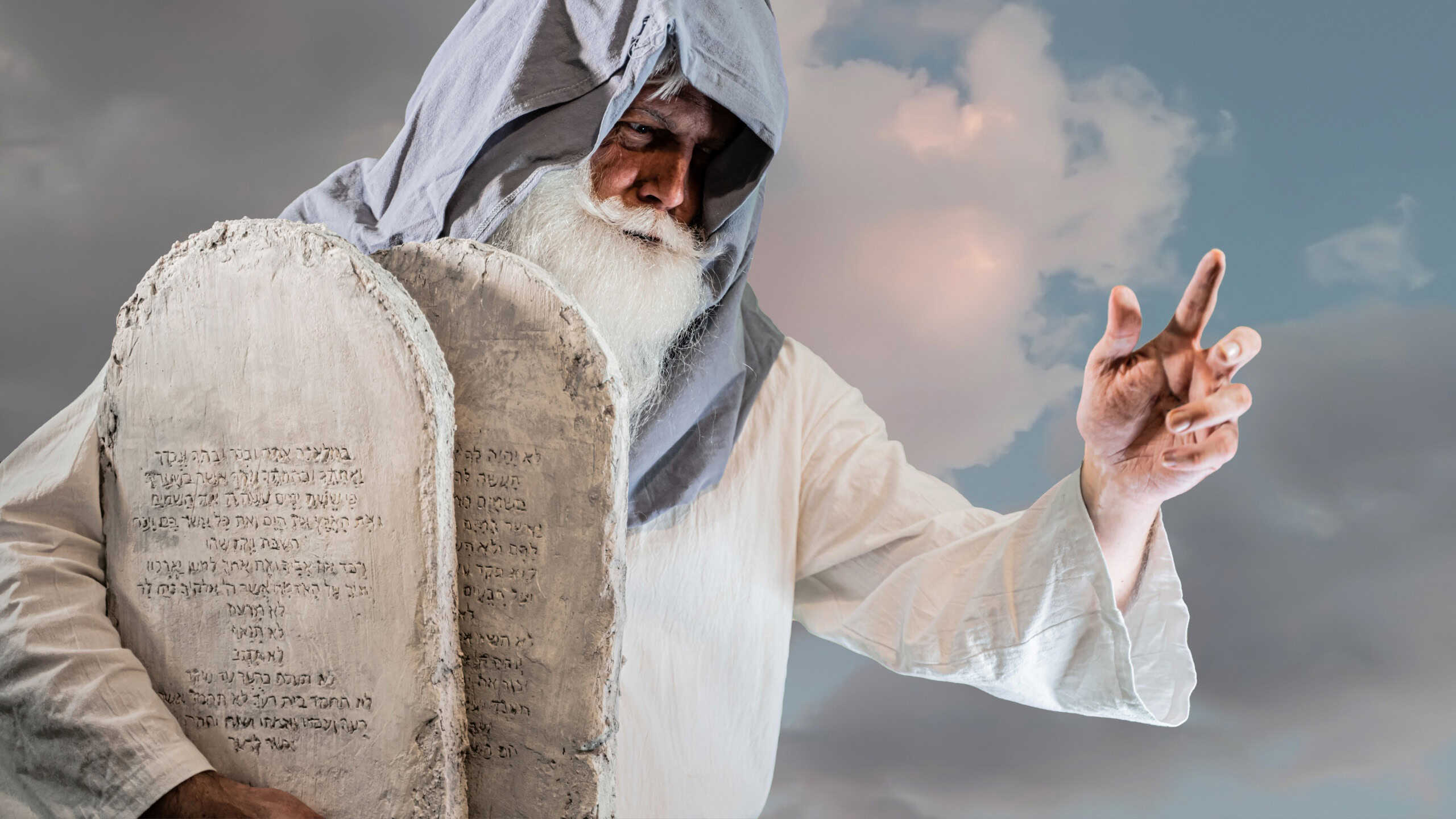 The Old Testament prophet Moses holds tablets with ten commandments on a white background