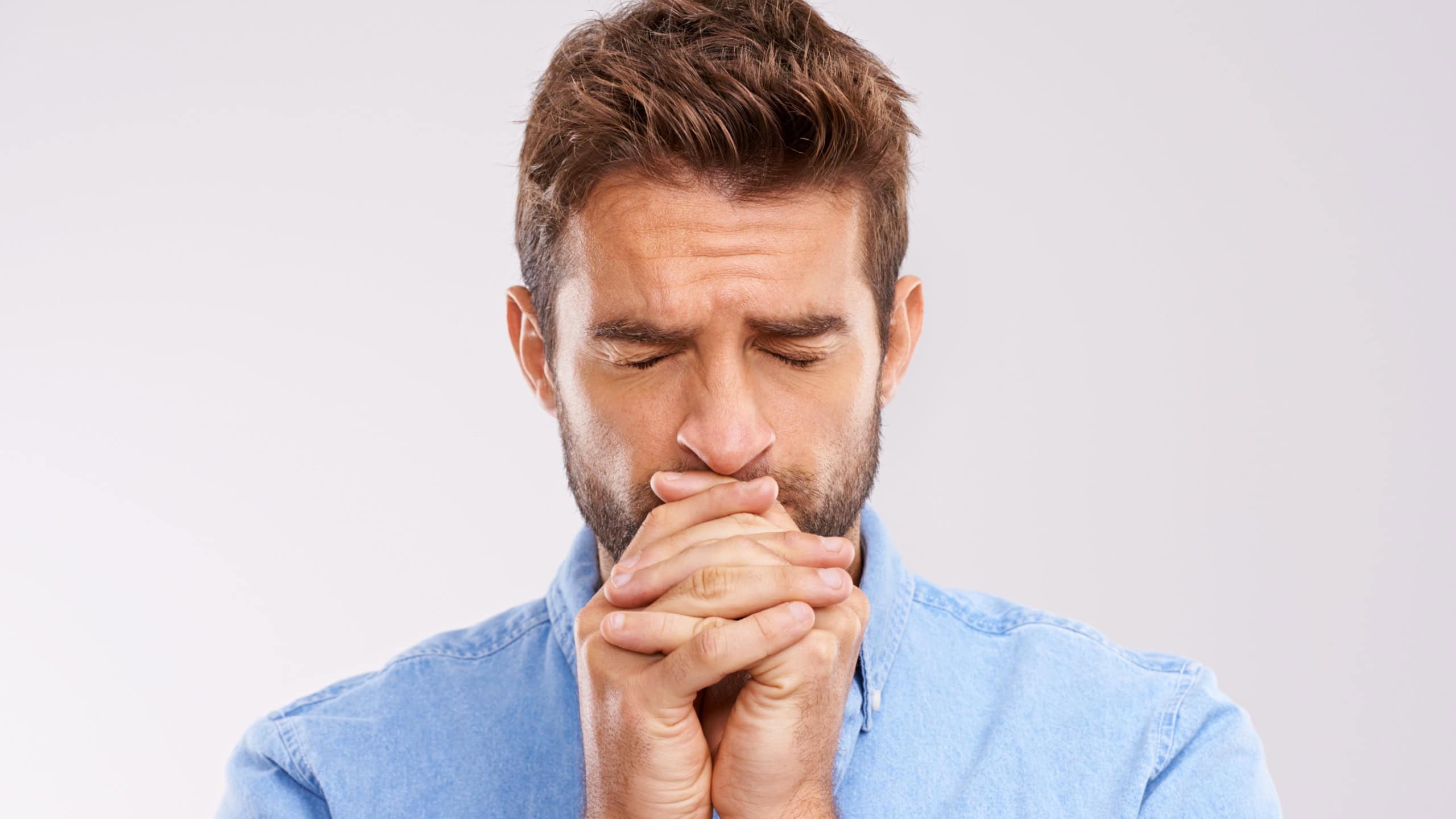 Man, praying and worship with anxiety and faith in God, seek help and advice for guidance on white background. Spiritual, religion and gratitude with thanks, stress and forgiveness with hope