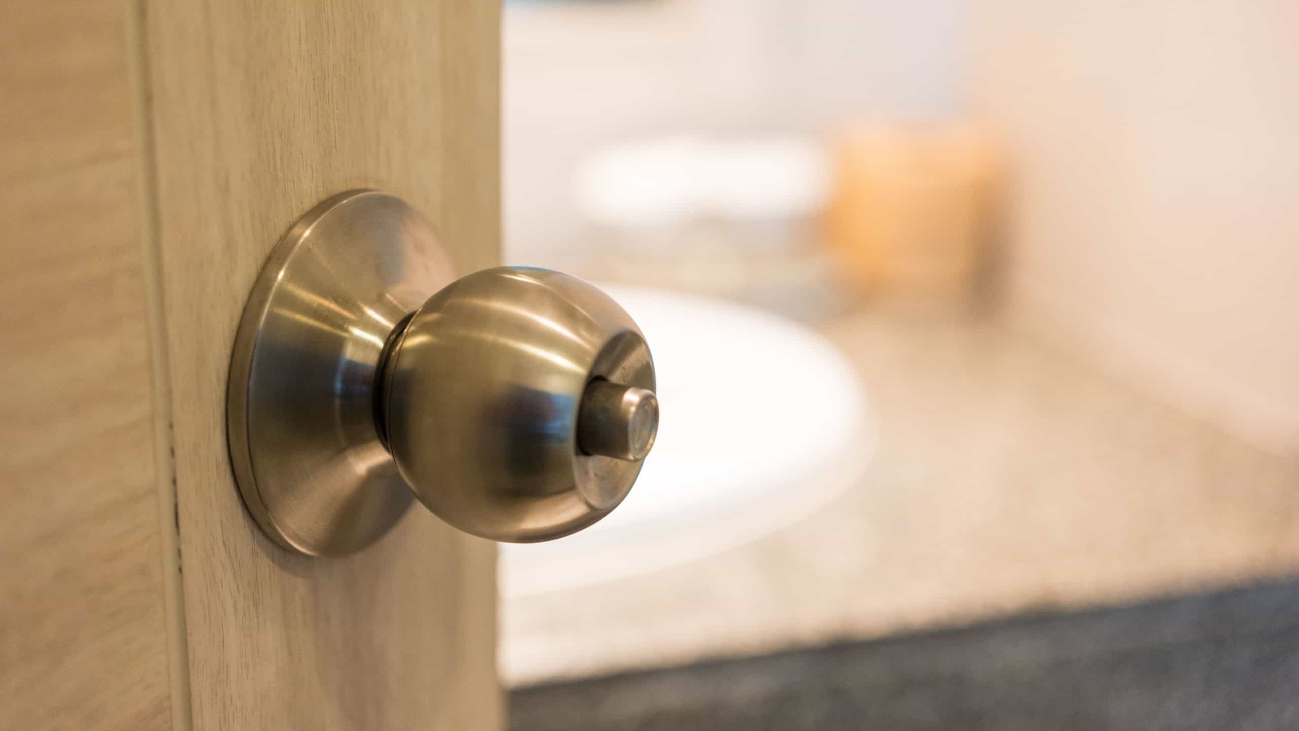 Door handle on open door in bathroom. Door knob or handle