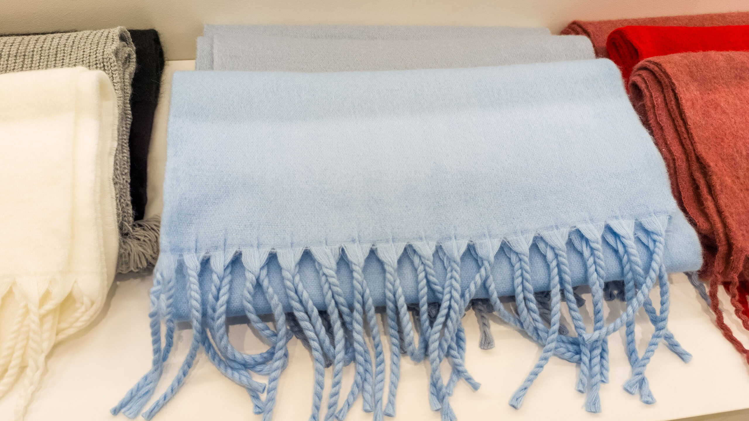A pile of blankets sitting on top of a white table.