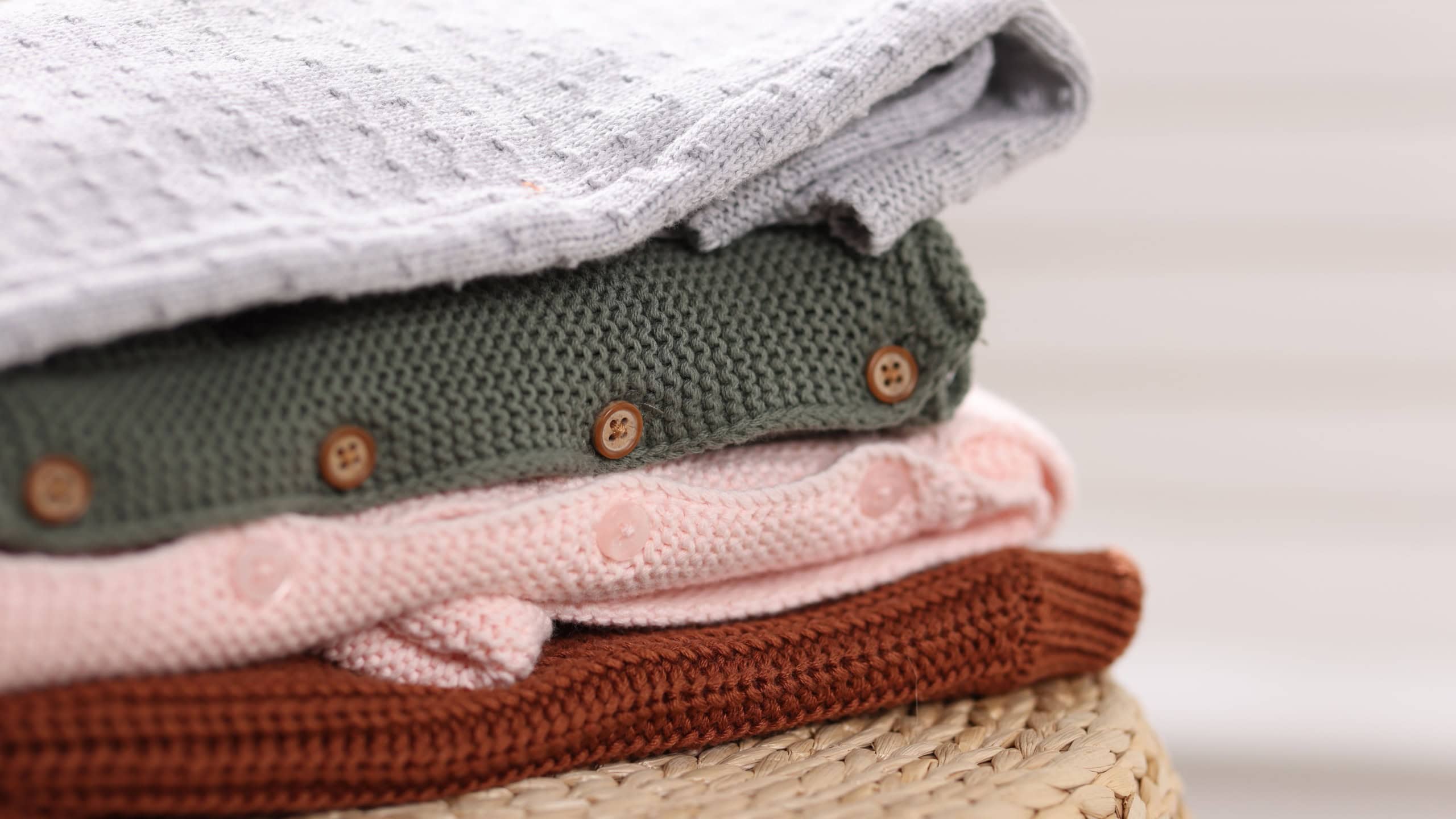 Wool baby clothes on wicker box indoors