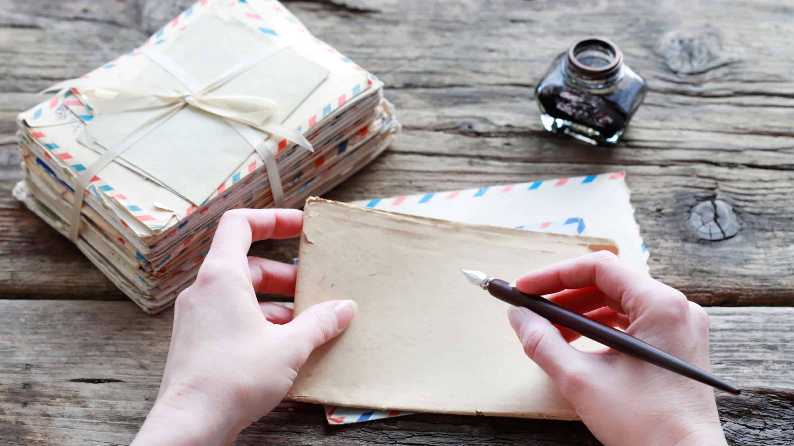 A woman holds a pen and a sheet of vintage paper. A stack of love letters stands in the background.