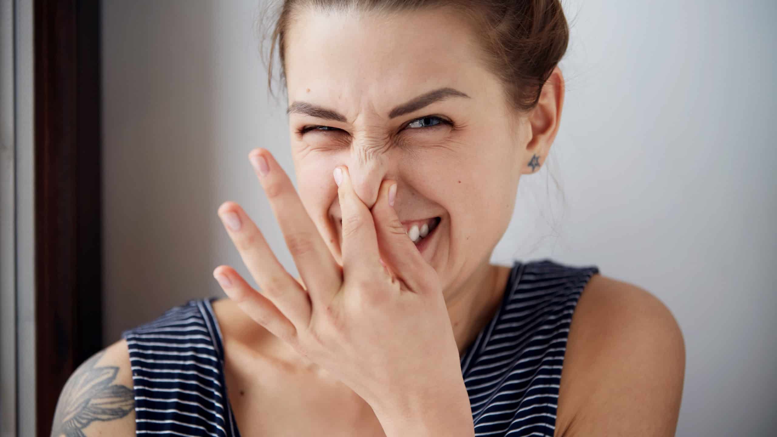 Female gesture smells bad. Headshot woman pinches nose with fingers hands looks with disgust something stinks bad smell situation. Human face expression body language reaction