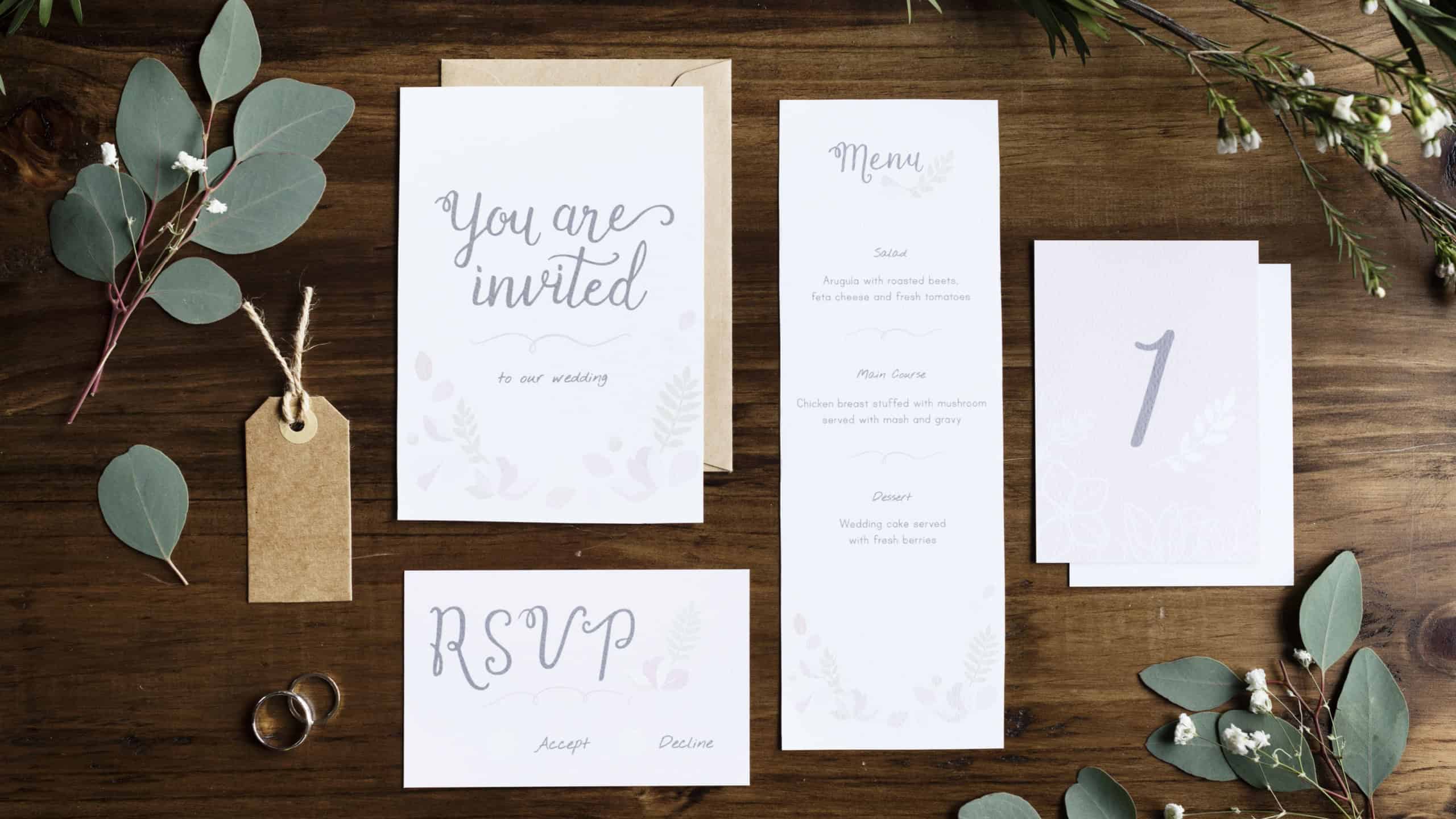 Wedding Invitation Cards Papers Laying on Table Decorate With Leaves