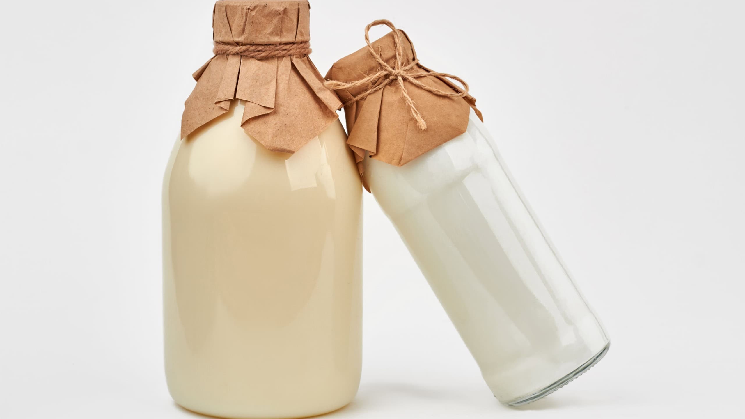 Bottles of organic milk on grey background. Fresh milk products in vintage glass bottles. Healthy dairy food.