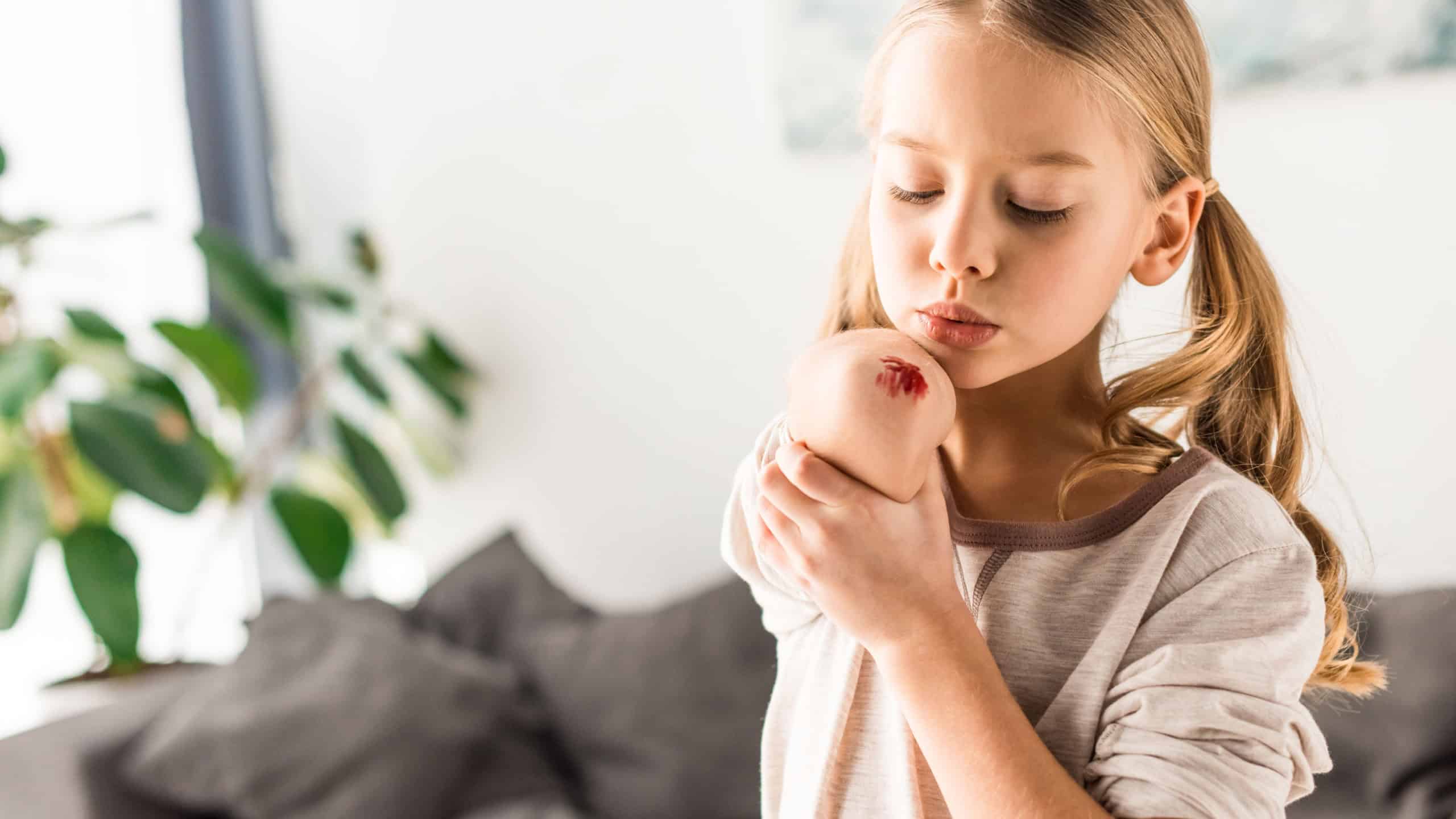 Upset kid blowing on wound at home