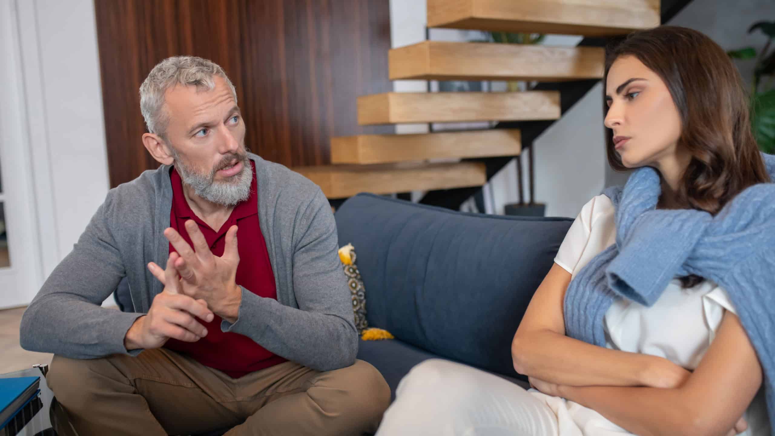 . A grey-haired man moralizing his young and beautiful spouse. A grey-haired man moralizing his young and beautiful spouse