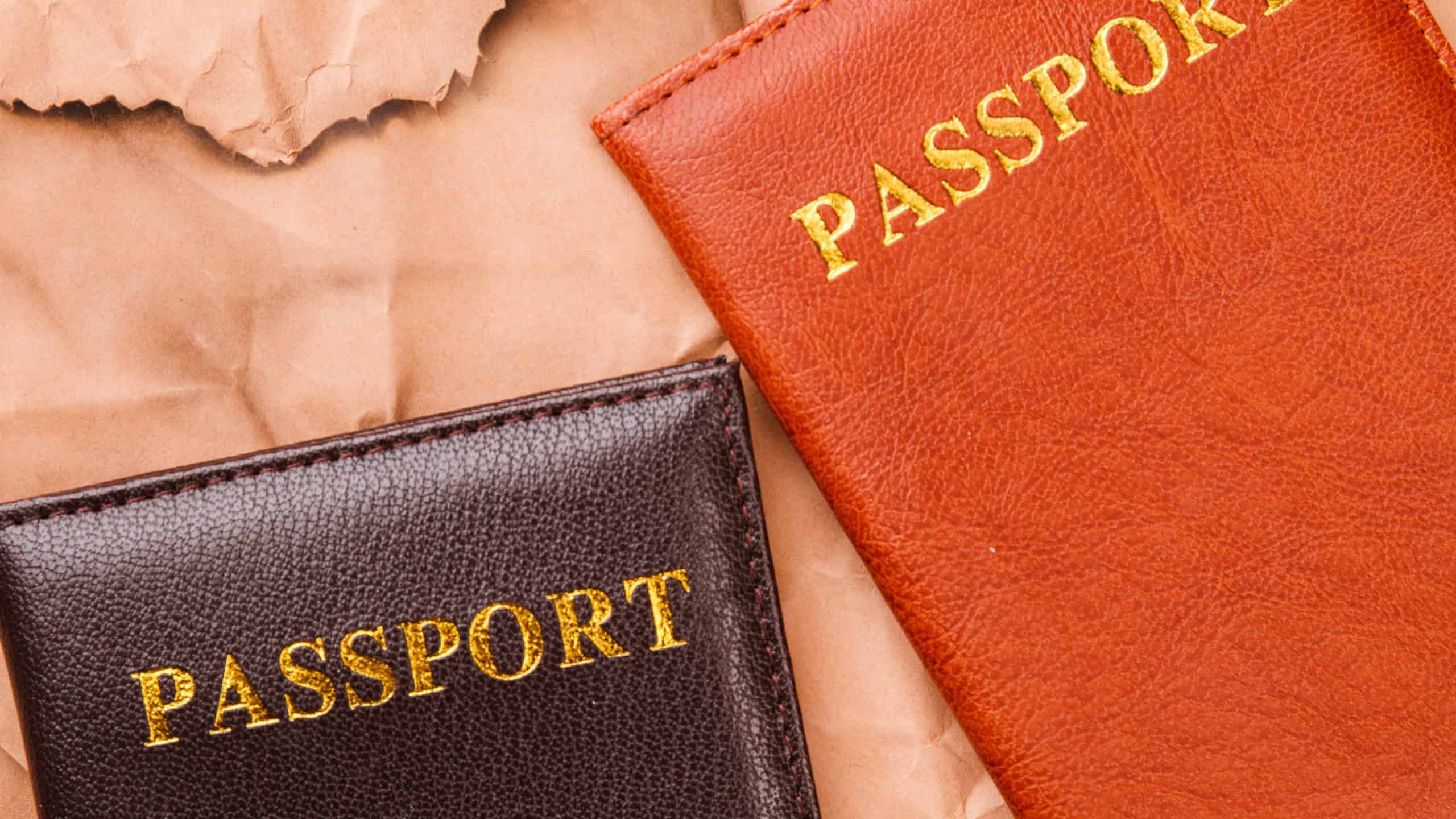Close-up two passports. Travel and immigration concept. Old worn paper background.