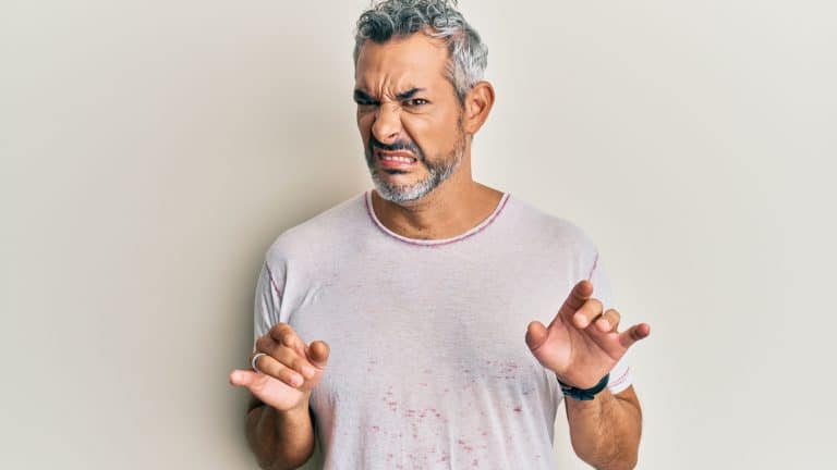 Middle age grey-haired man wearing casual clothes disgusted expression, displeased and fearful doing disgust face because aversion reaction. with hands raised