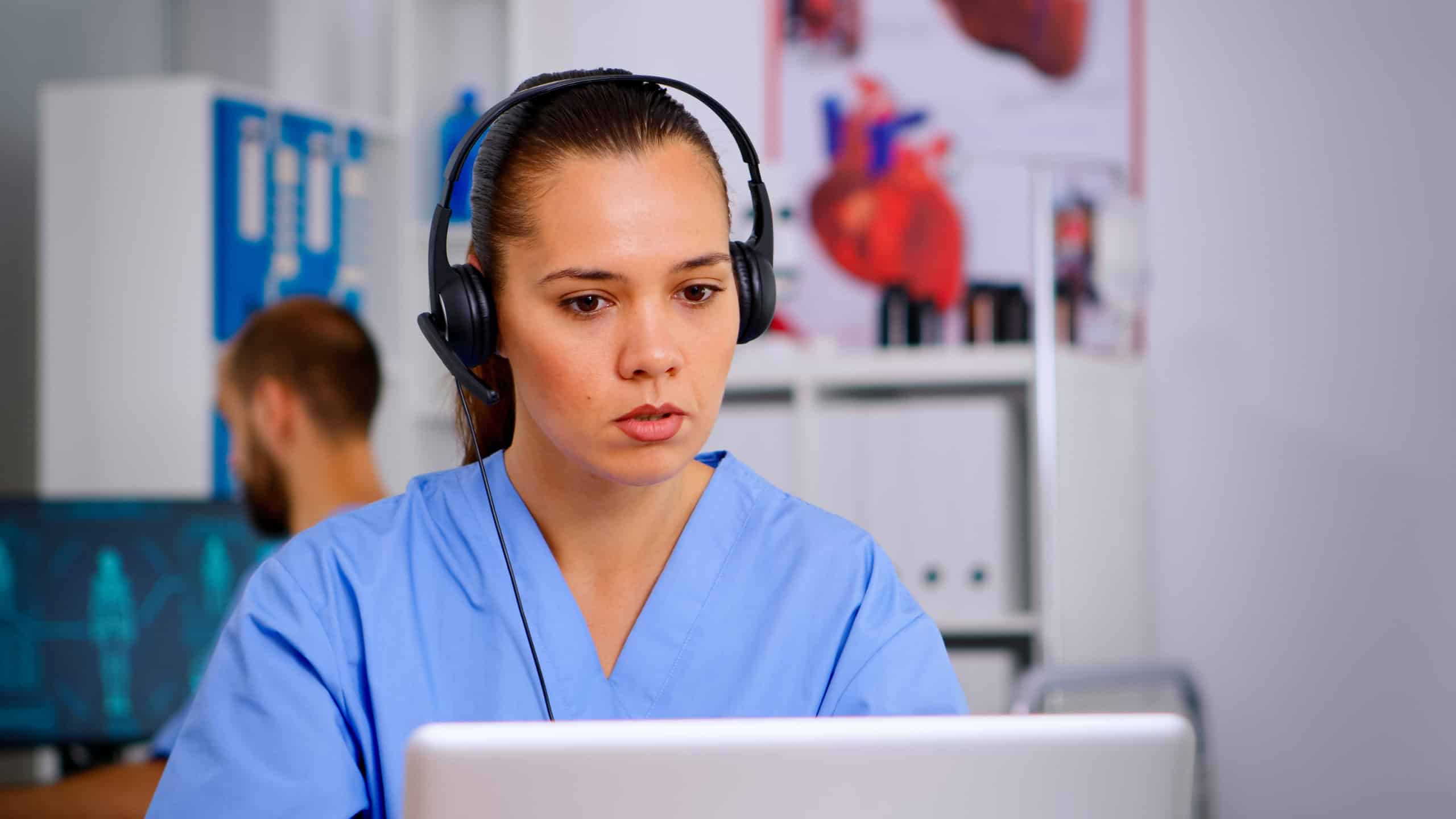 Doctor assistant using headphones in hospital answering to patients calls for appointments and consultations. Healthcare physician in medicine uniform, doctor nurse helping with telehealth