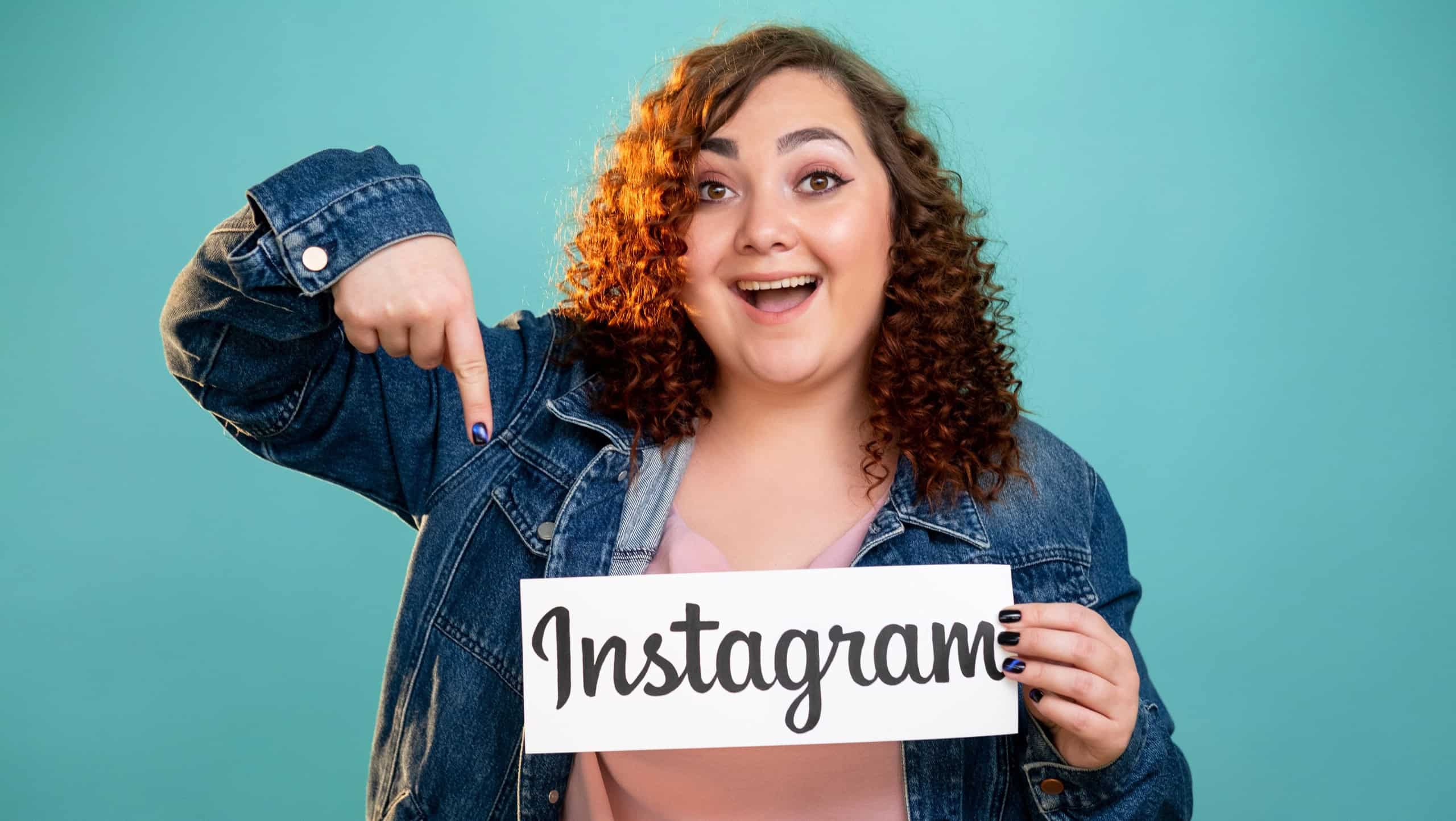Kharkiv, Ukraine - November 06, 2020: Instagram profile. Social network. Mobile application. Public account. Happy plus size woman pointing on paper note with symbol icon isolated blue.