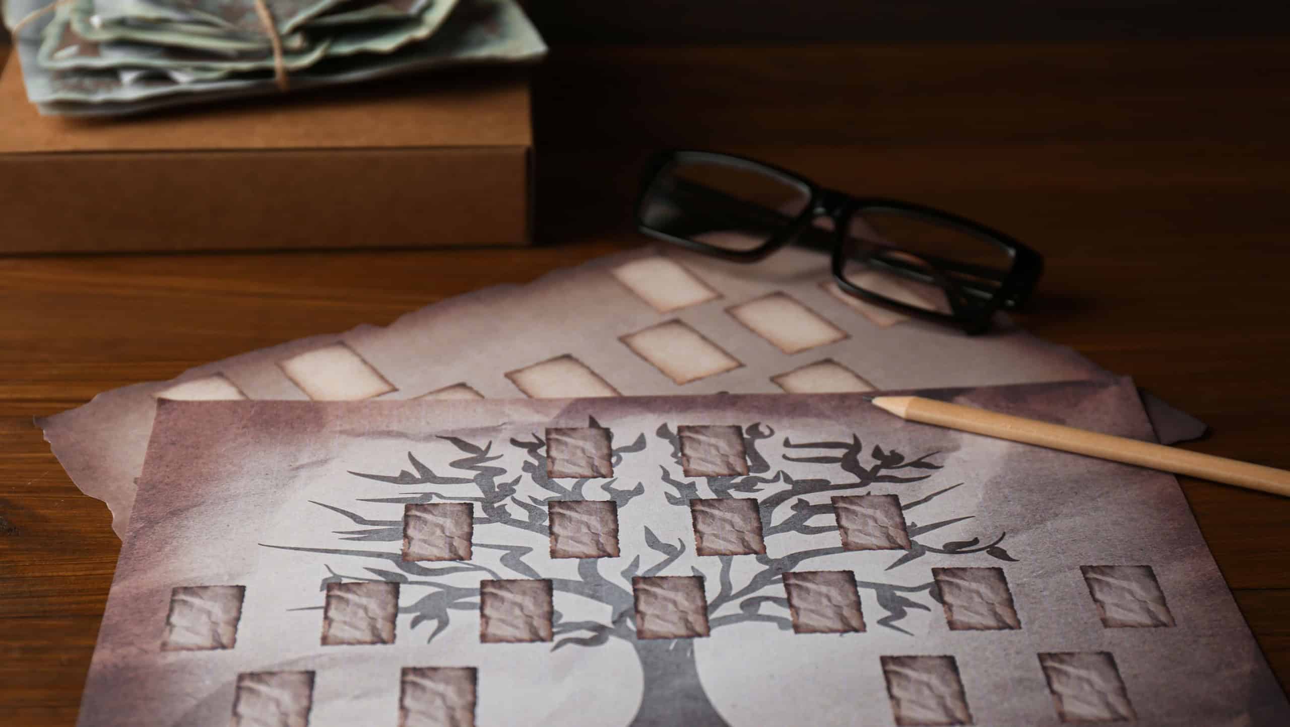 Papers with family tree templates, pencil, photos and glasses on wooden table, closeup