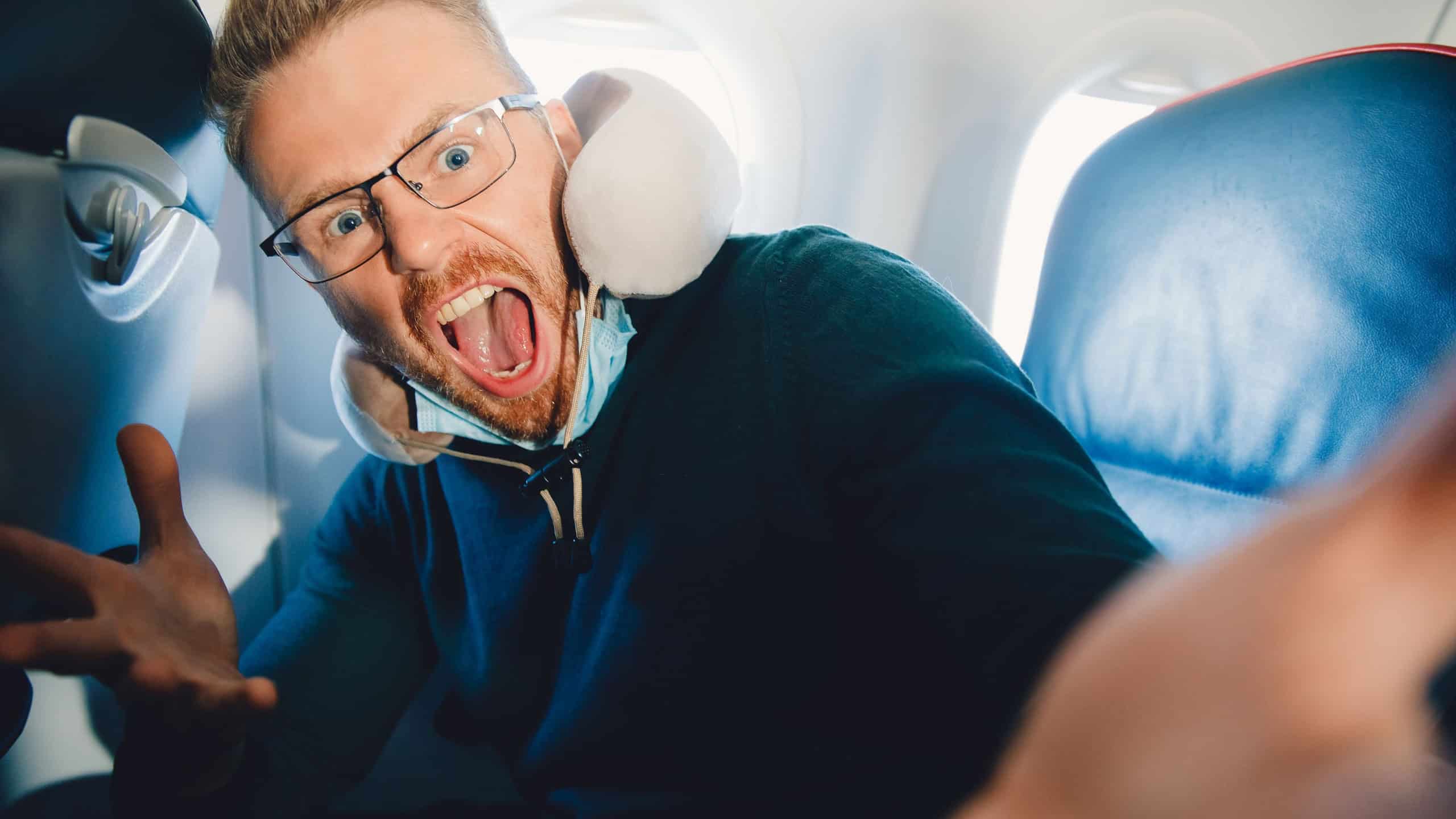 Concept of aerophobia, male tourist is afraid of flying on airplane.