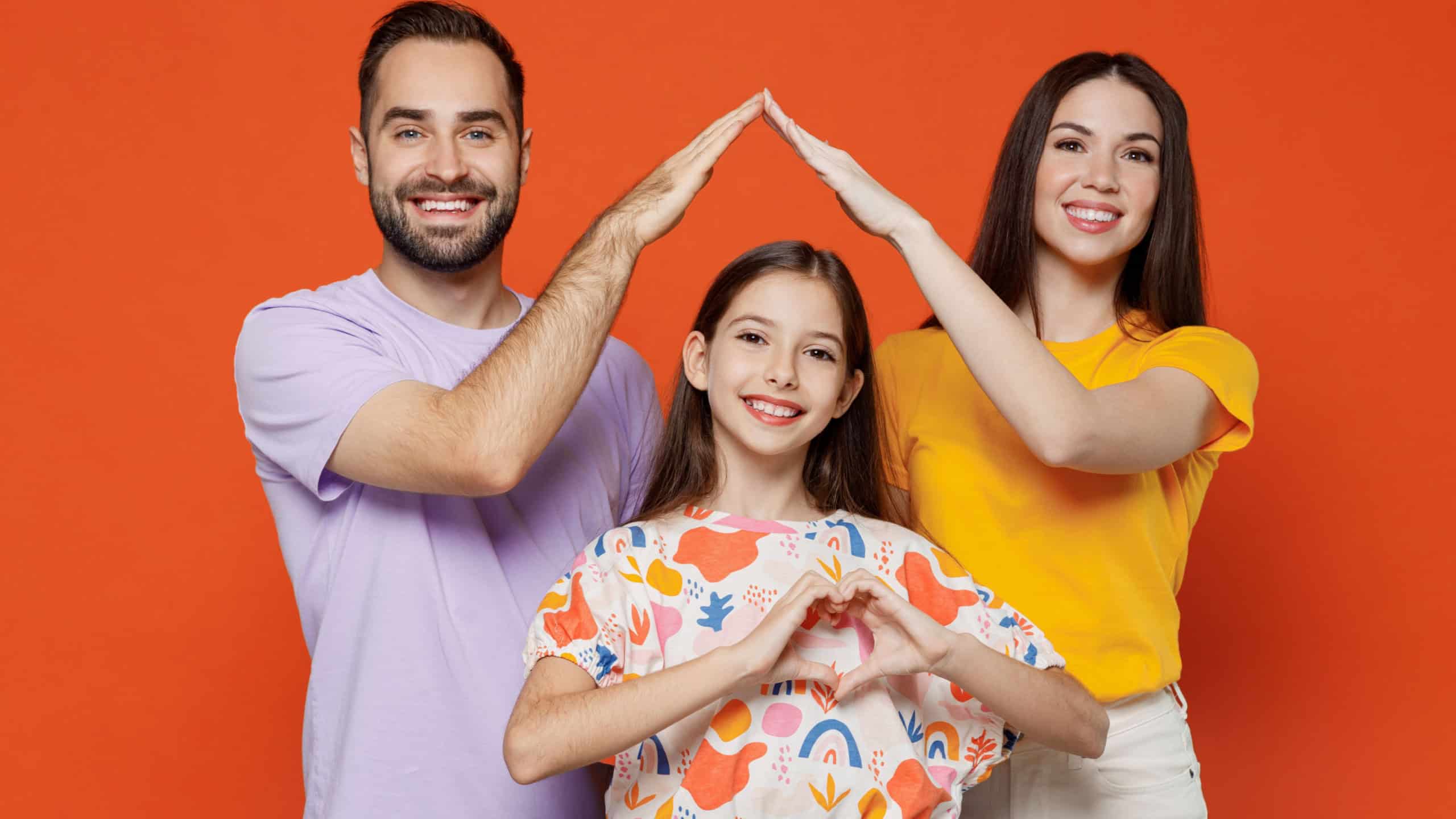 Young fun parents mom dad with child kid daughter teen girl in basic t-shirts hold folded hands above head like house roof, stay home isolated on yellow background studio portrait Family day concept