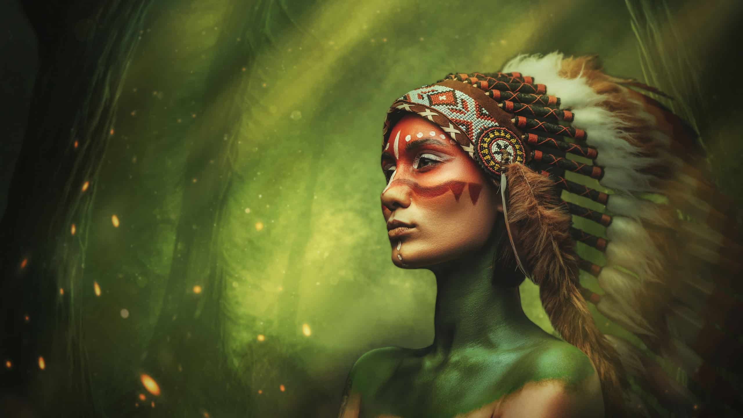 Painted indian woman with headdress in fairy tale green forest