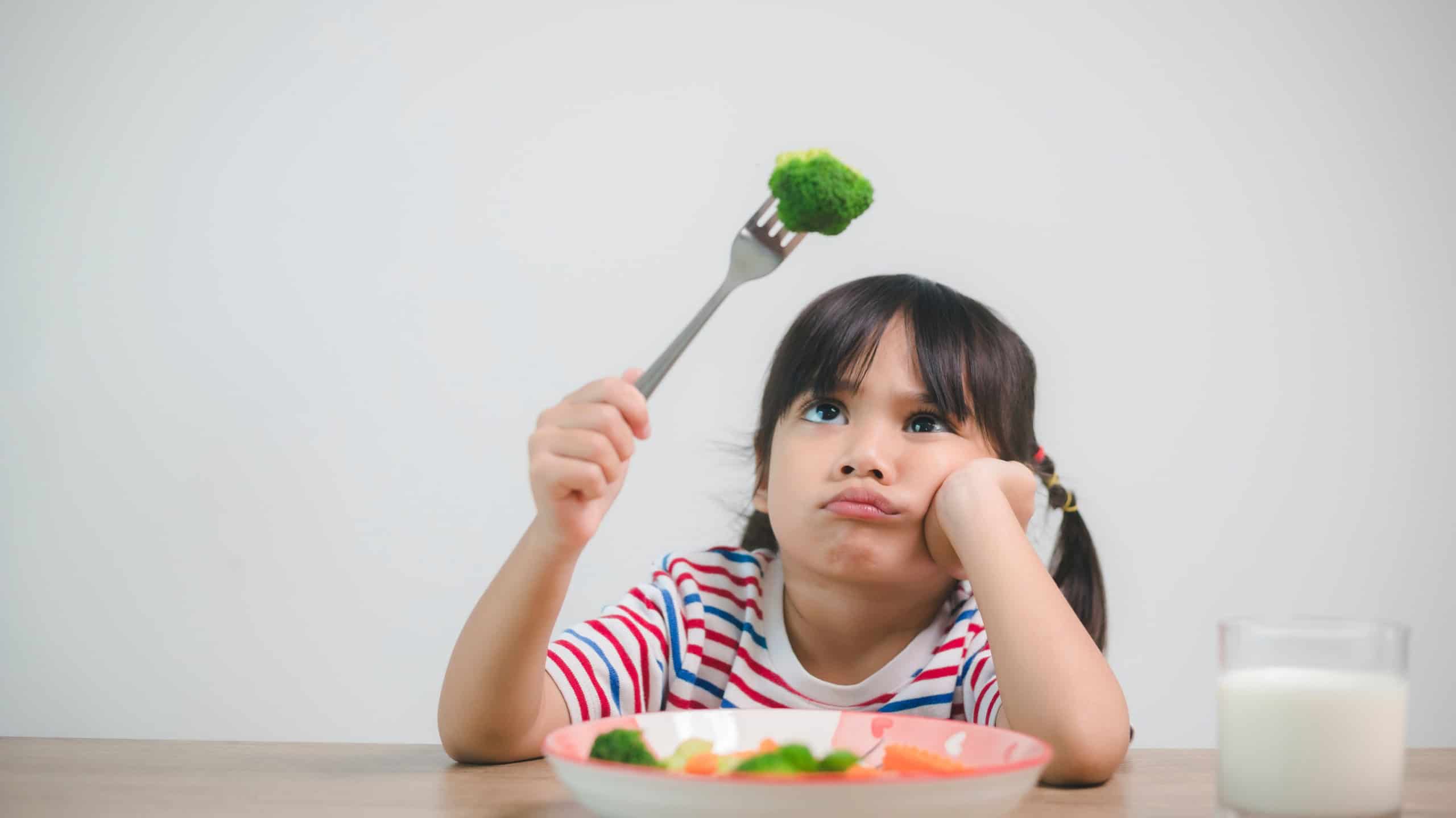 Nutrition healthy eating habits for kids concept. Children do not like to eat vegetables. Little cute girl refuses to eat healthy vegetables.