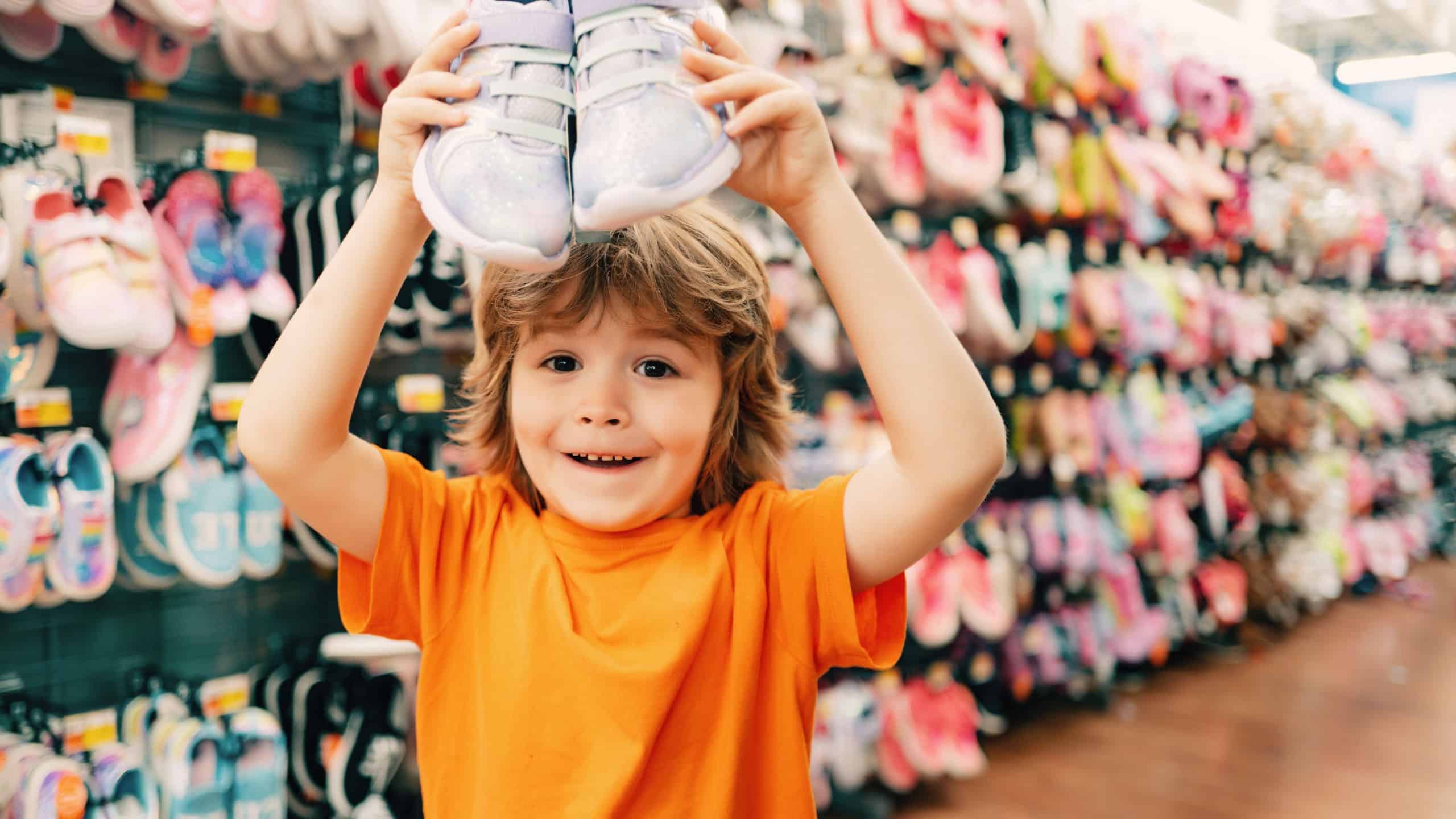 Kids shopping. Sale, consumerism and people concept. Kids shoes store in supermarket, choosing kids in shoes store. Shoes store for kids.