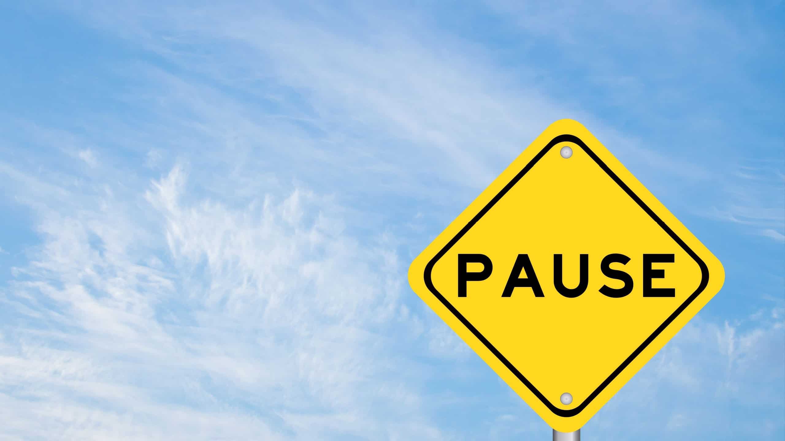 Yellow transportation sign with word pause on blue color sky background