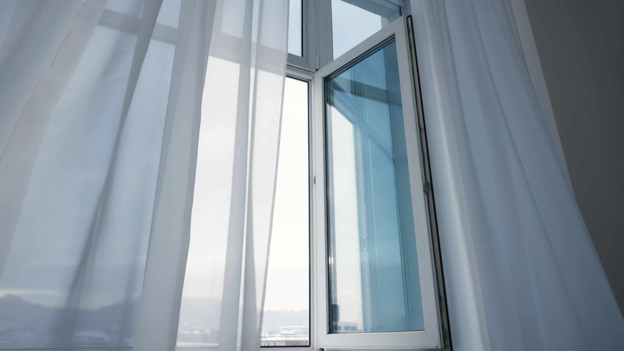 Open window and elegant white curtains indoors