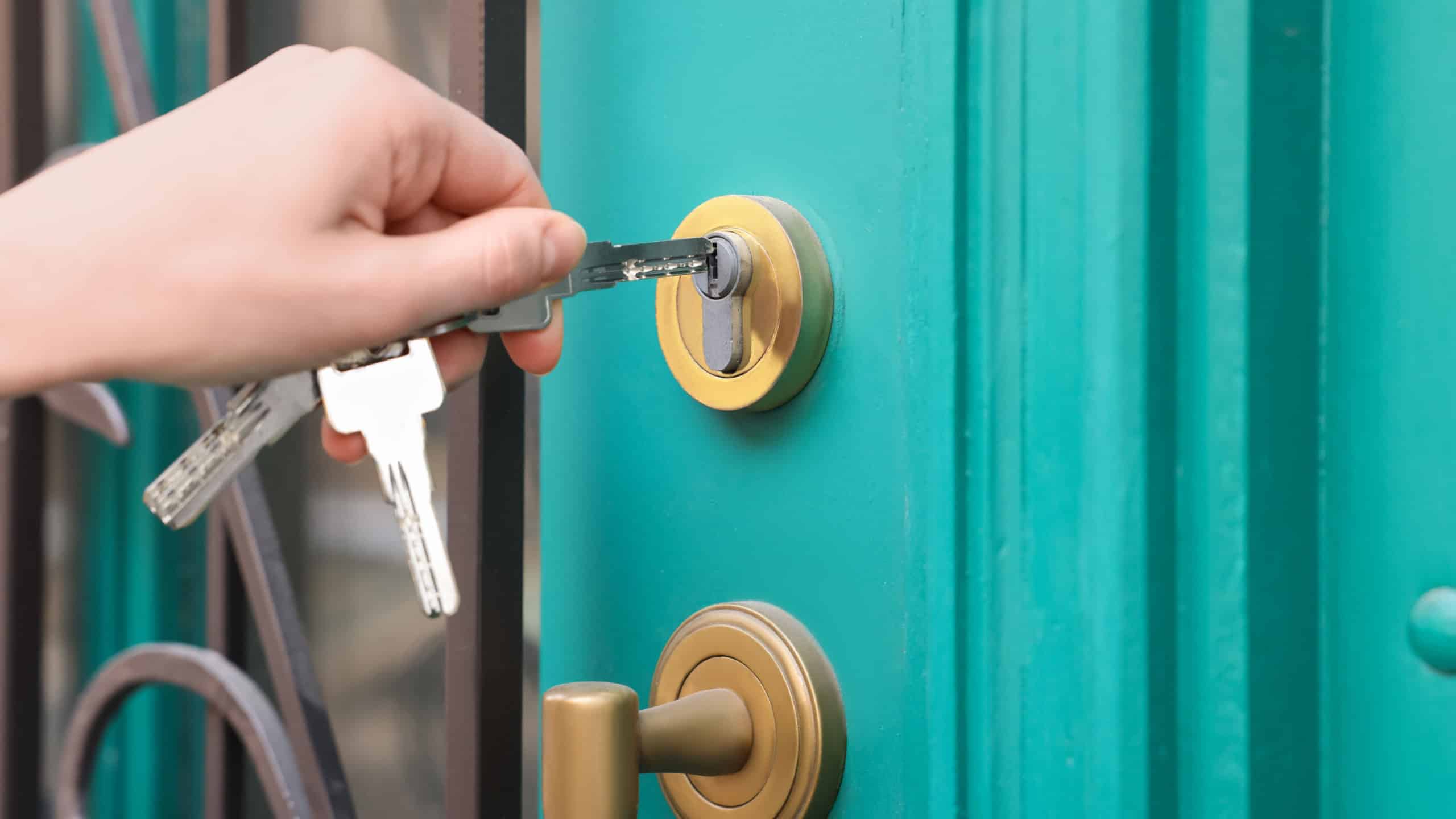Woman opening door with key outdoors
