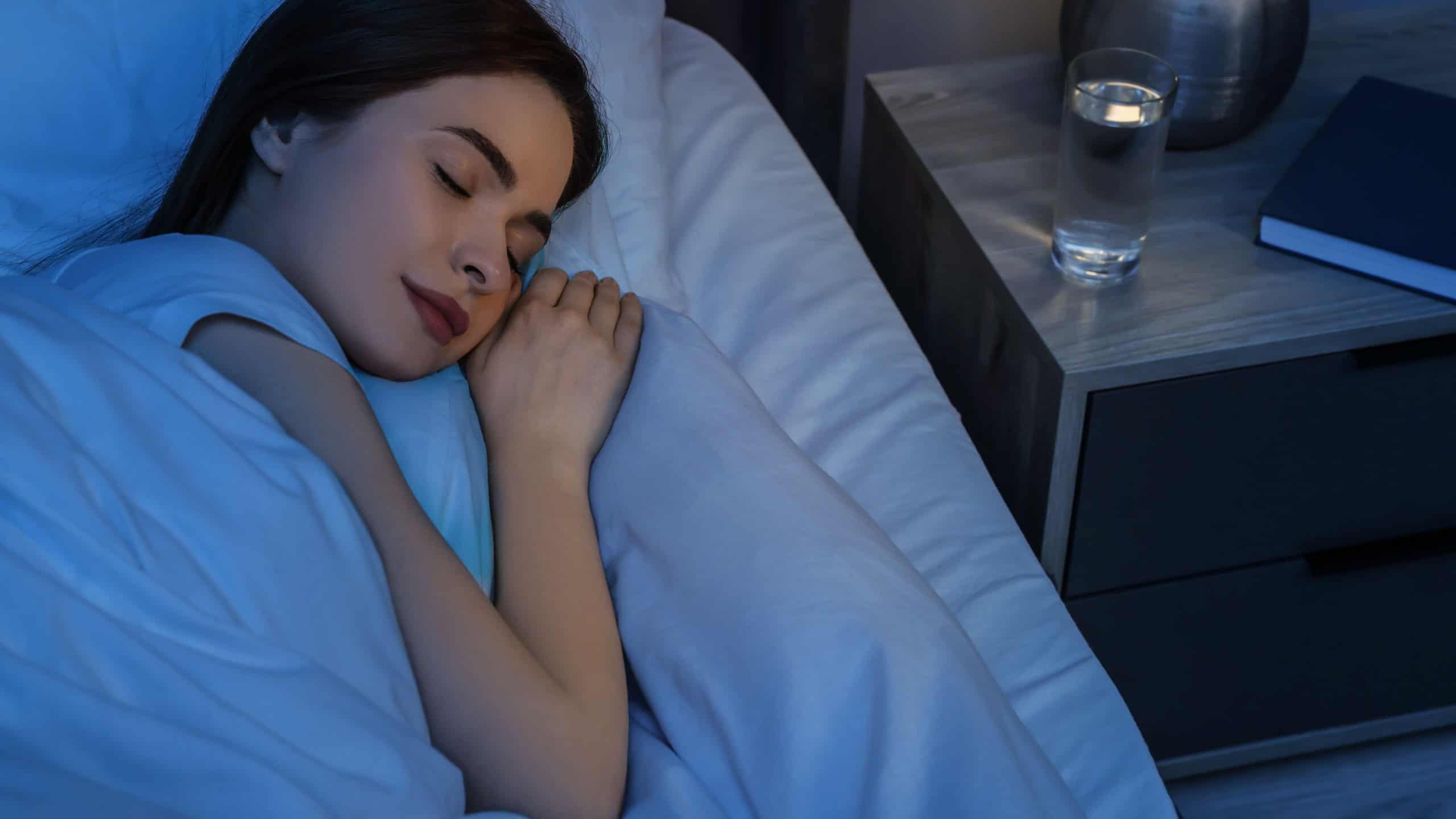 Beautiful young woman sleeping in bed at night