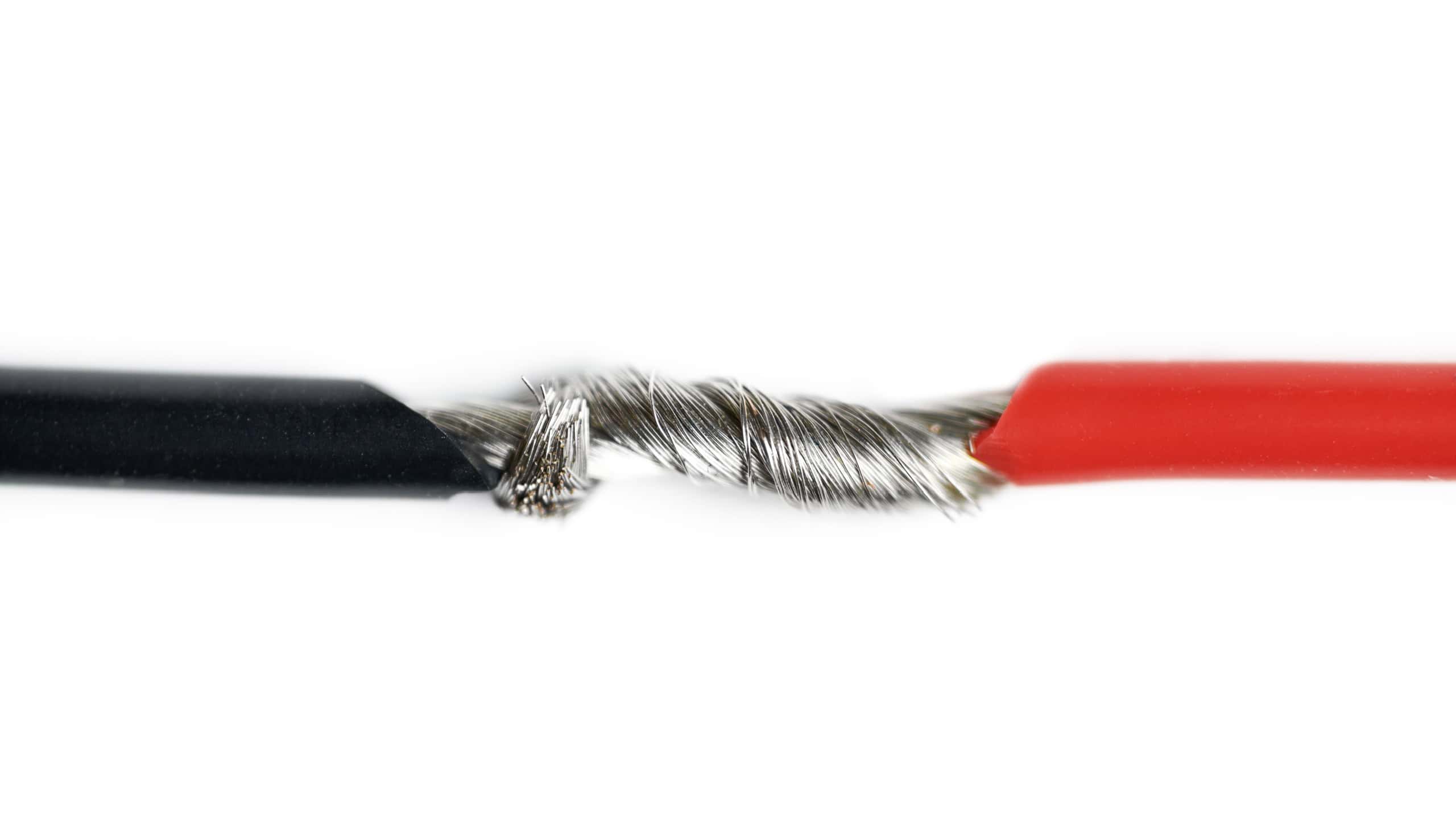 Isolated aluminum bare wires of electric cable. Red and black wires without insulation for speakers or power.