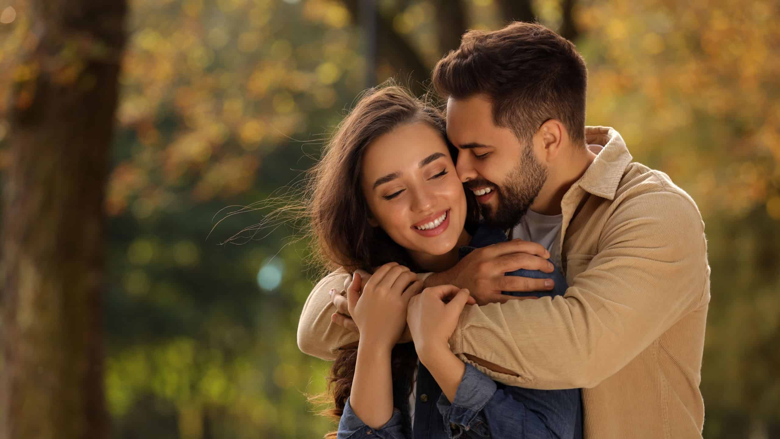 Beautiful couple hugging in autumn park, space for text